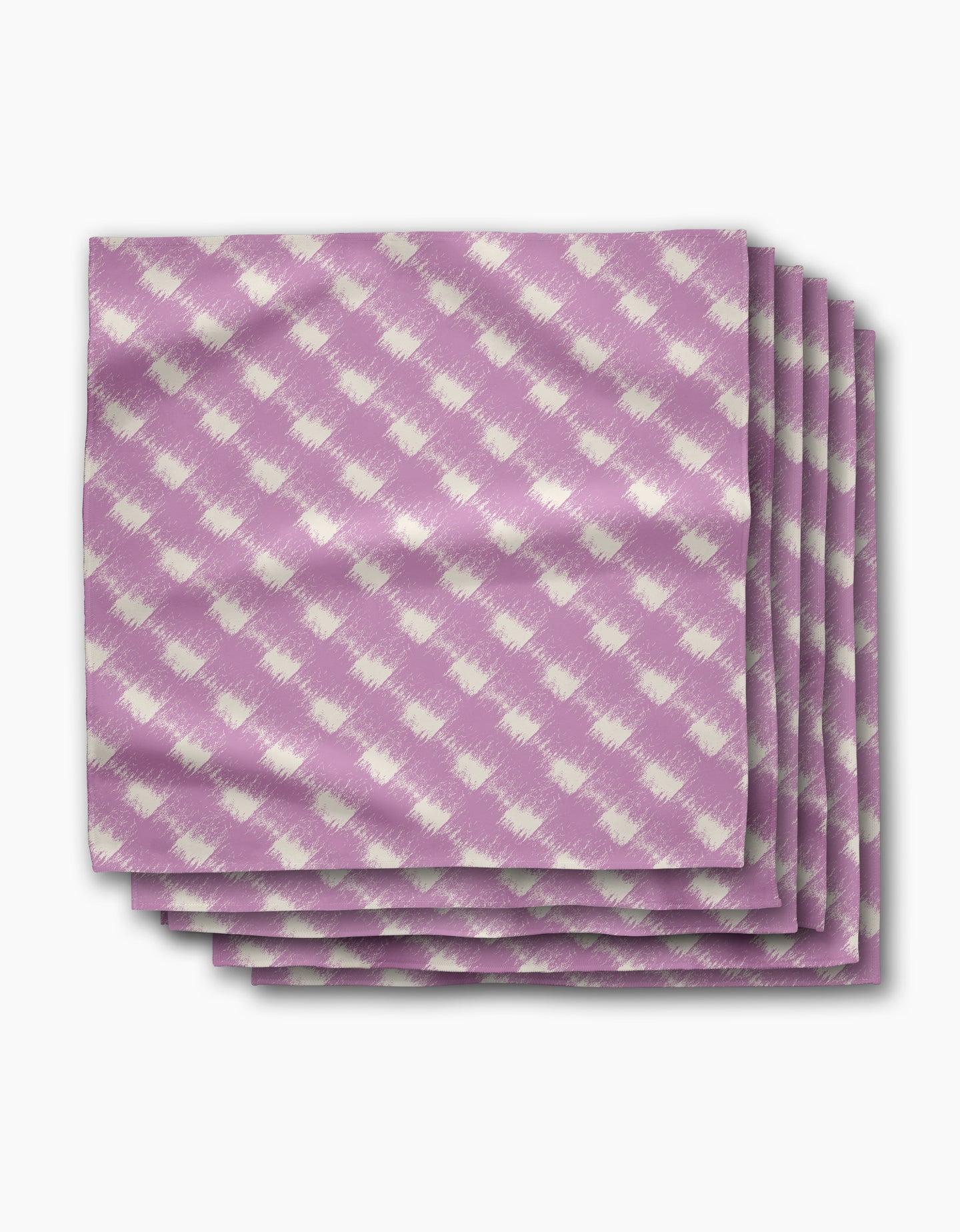 A stack of four Geometry Hairy Check Pink dinner napkins, featuring a white diagonal checkered pattern on Geosuede fabric, is displayed on a white background.