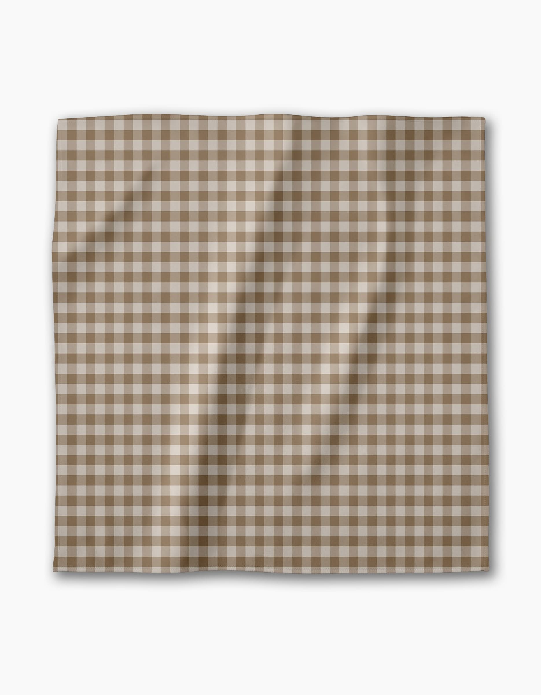 The Hazel Gingham reusable cloth napkin by Geometry features a brown and white checkered pattern, shown laid flat with gentle folds on a plain white background—ideal for an eco-friendly dinner napkin set.