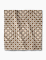 The Heritage Stamp dinner napkin set by Geometry features a square beige fabric with a geometric pattern of brown diamonds and tan squares. Made from recycled materials, these eco-friendly napkins bring style to your table setting.