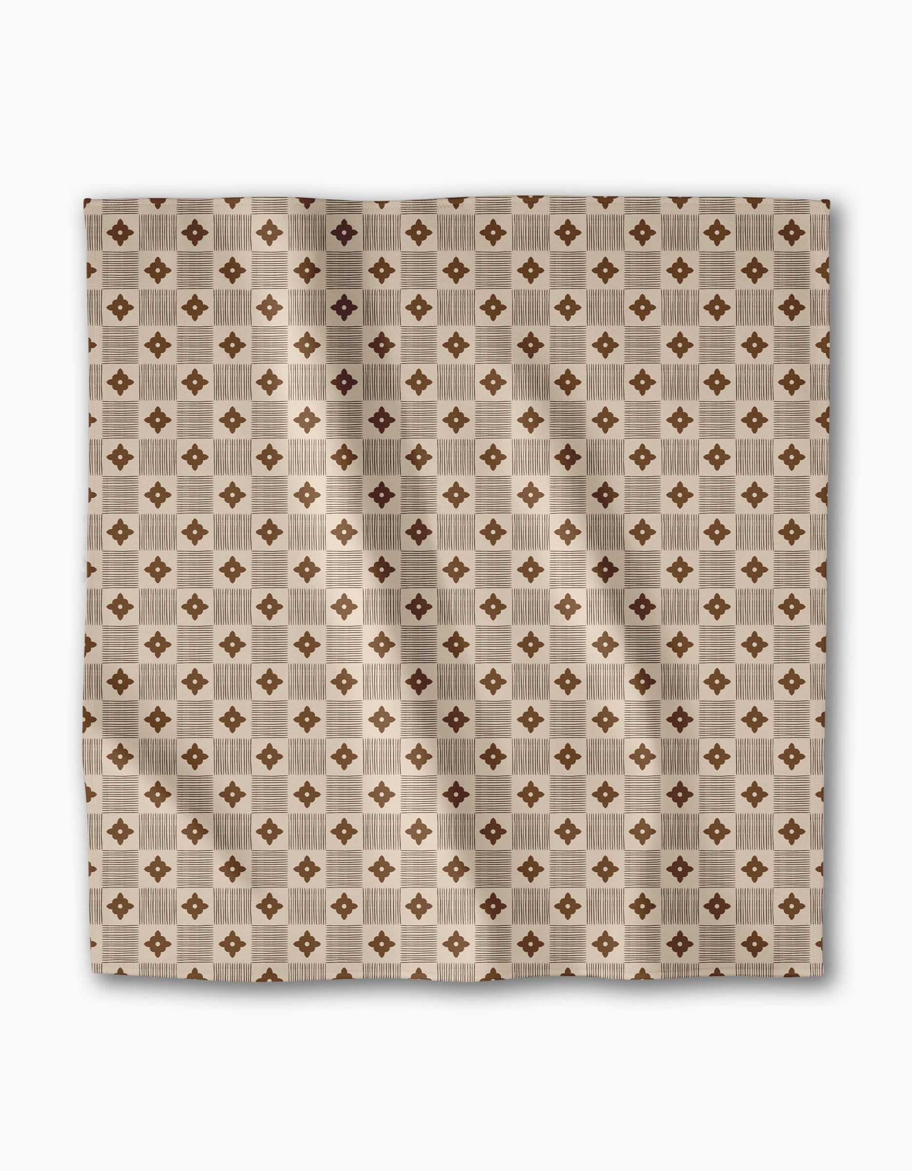 The Heritage Stamp dinner napkin set by Geometry features a square beige fabric with a geometric pattern of brown diamonds and tan squares. Made from recycled materials, these eco-friendly napkins bring style to your table setting.