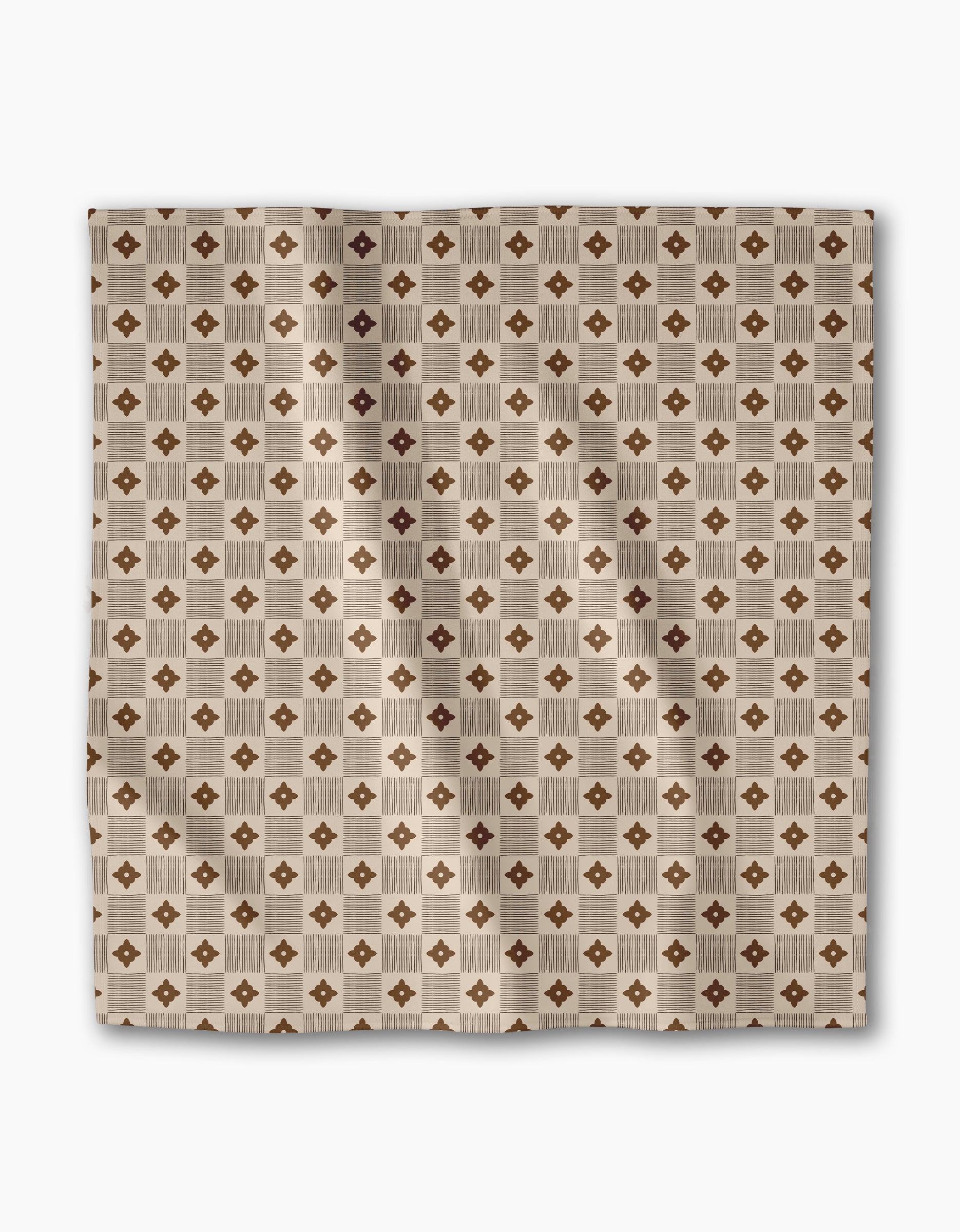 The Heritage Stamp dinner napkin set by Geometry features a square beige fabric with a geometric pattern of brown diamonds and tan squares. Made from recycled materials, these eco-friendly napkins bring style to your table setting.