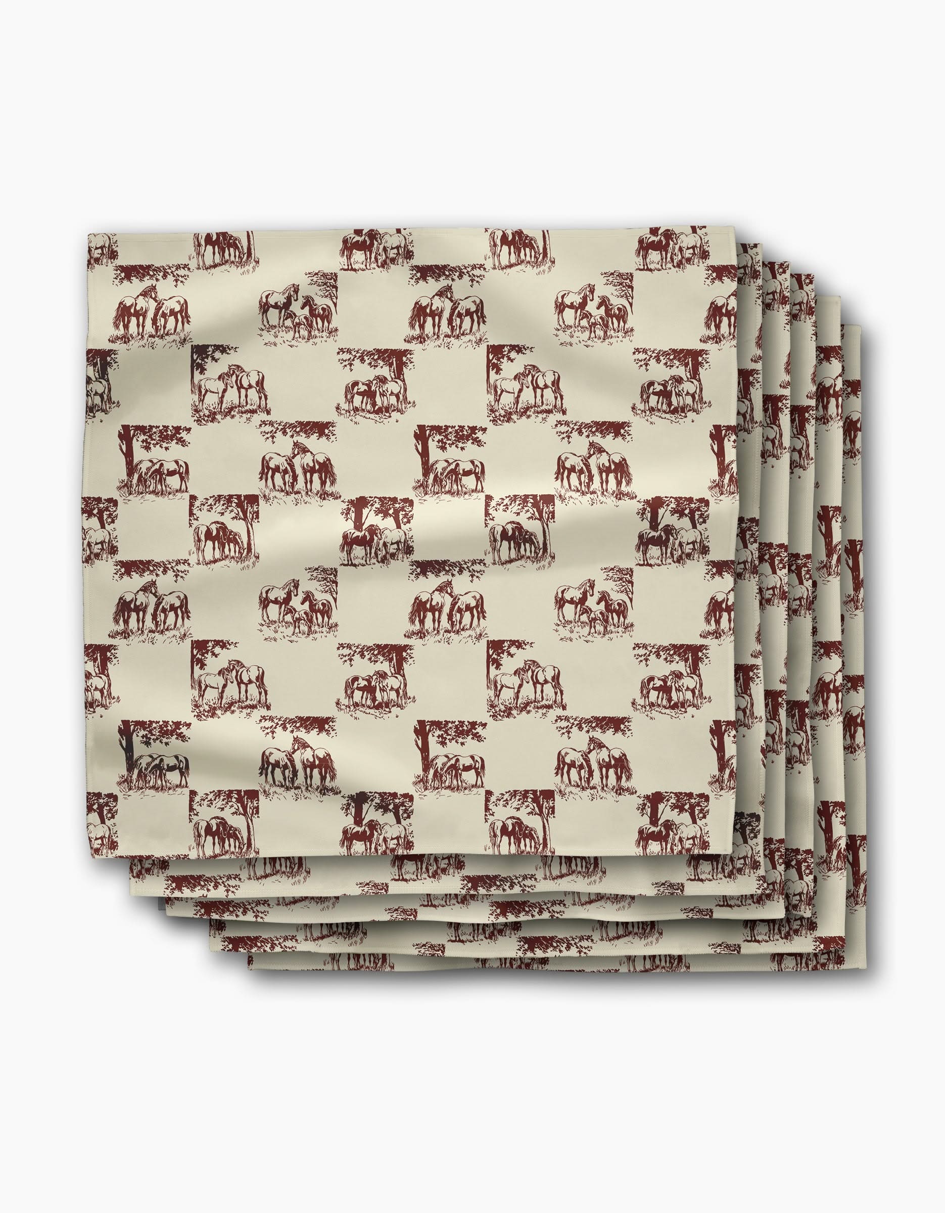 Four folded Geometry Horse Check Cream dinner napkins, featuring a repeating brown horse pattern on beige, are stacked neatly on a white background. These reusable napkins bring charm and sustainability to your table setting.