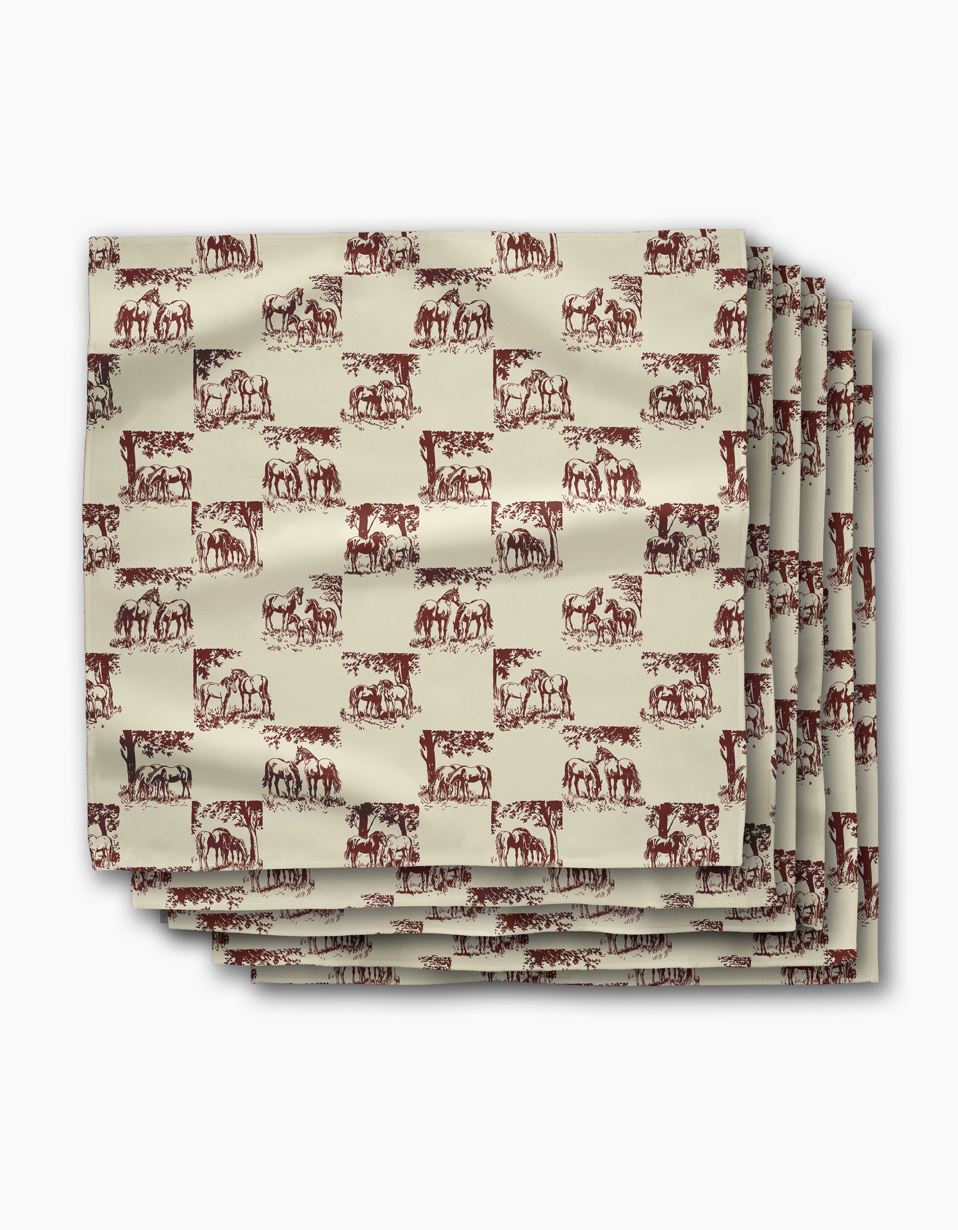 Four folded Geometry Horse Check Cream dinner napkins, featuring a repeating brown horse pattern on beige, are stacked neatly on a white background. These reusable napkins bring charm and sustainability to your table setting.