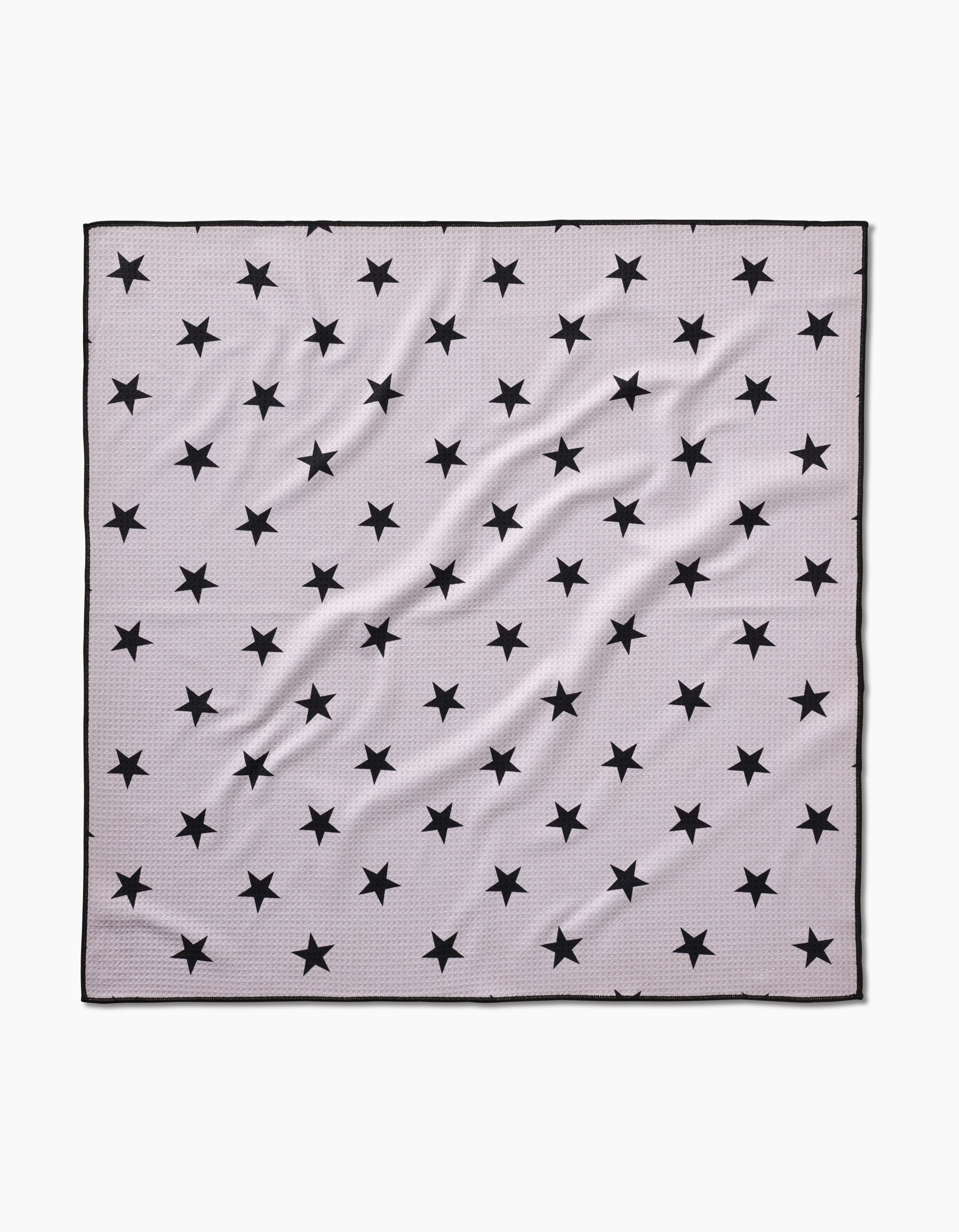 The Bark scarf by Geometry is a square, light gray piece made from recycled materials, featuring a pattern of evenly spaced black stars, a thin black border, and slight fabric wrinkles.