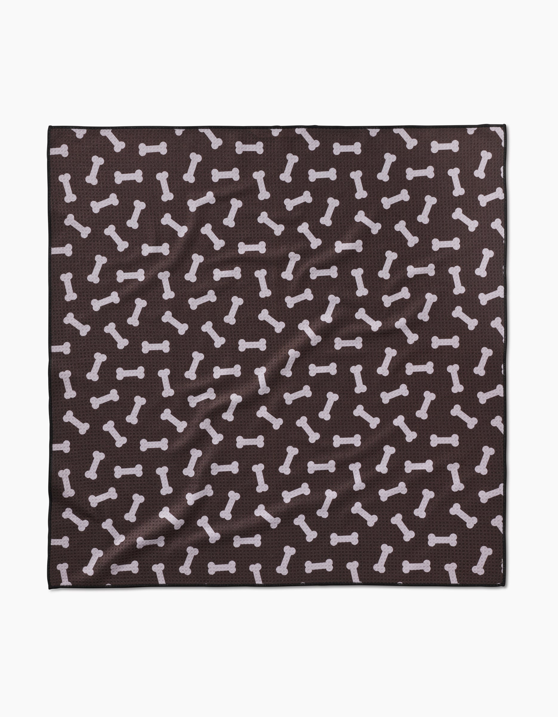 The Geometry Sweet Treats is a black square cloth made from recycled materials, decorated with a pattern of white dog bones scattered across its surface.