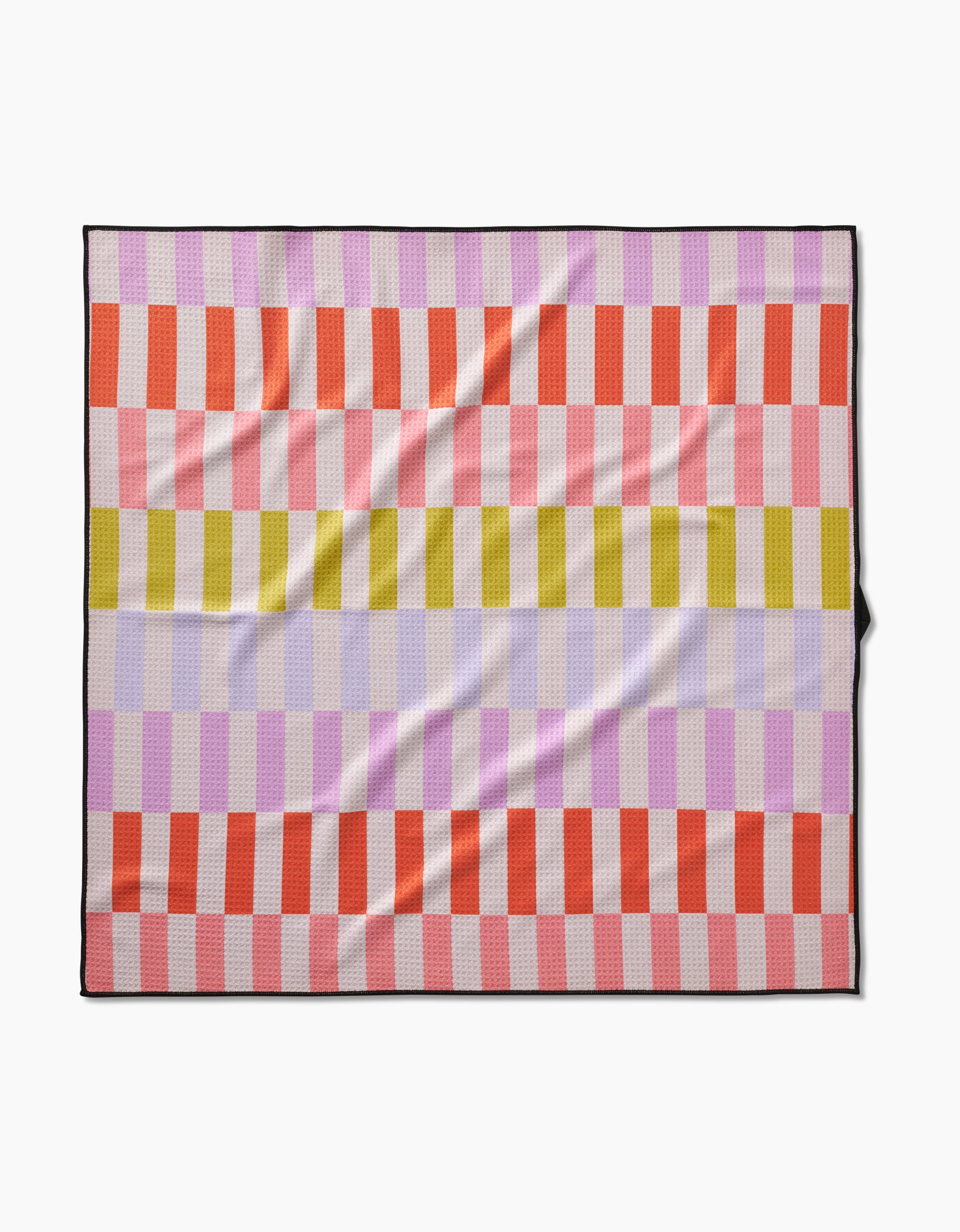 The Geometry Wag Wise blanket features a checkered pattern with horizontal stripes in red, light pink, yellow, and lavender, each formed by alternating squares. Made from recycled materials with a black border, it’s shown laid flat.