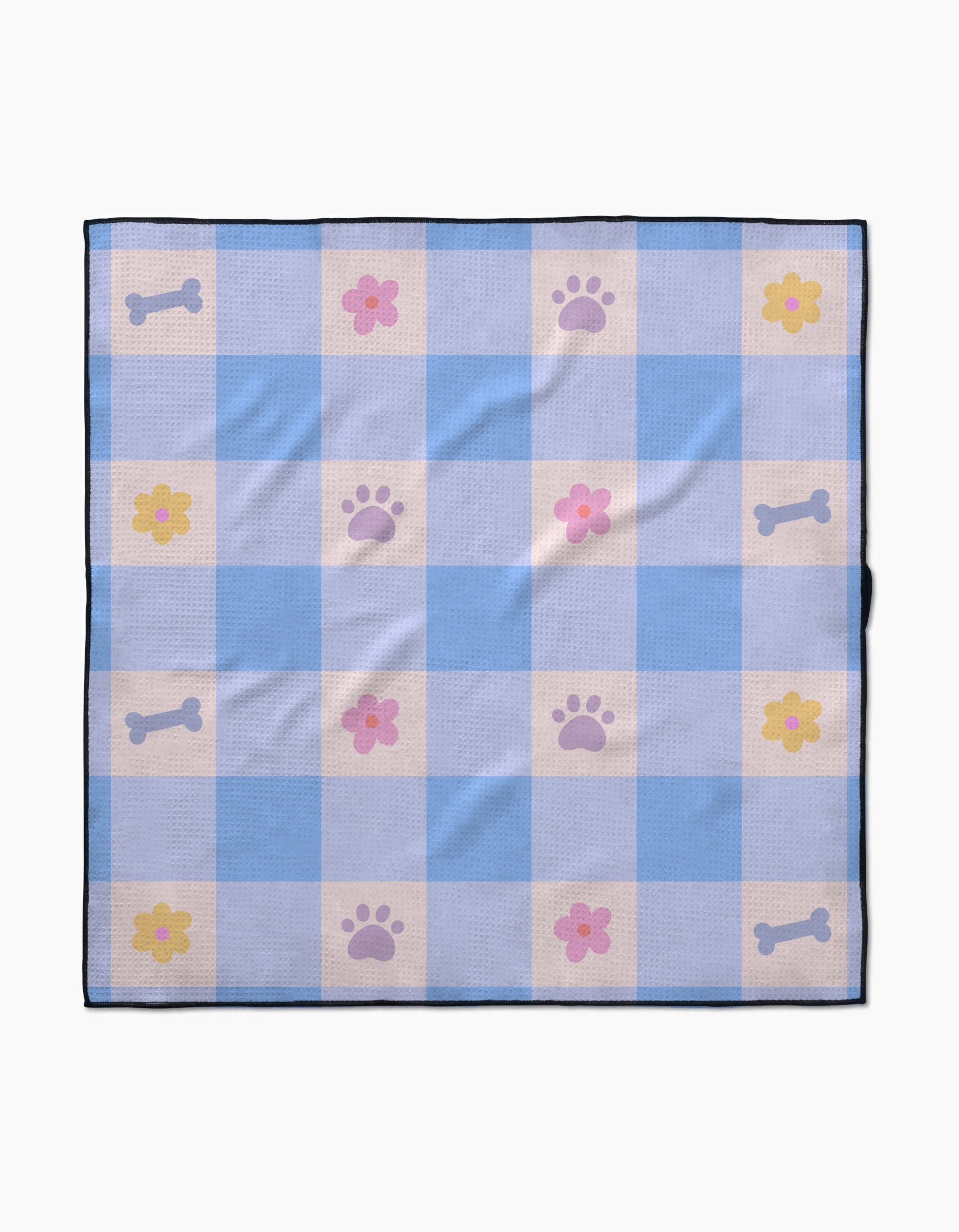 The Blue Sky Picnic Dreams dog towel by Letters By Shells features blue and white checks with pink flowers, purple paw prints, and light gray dog bones. Made from recycled materials, it’s finished with a dark blue border.