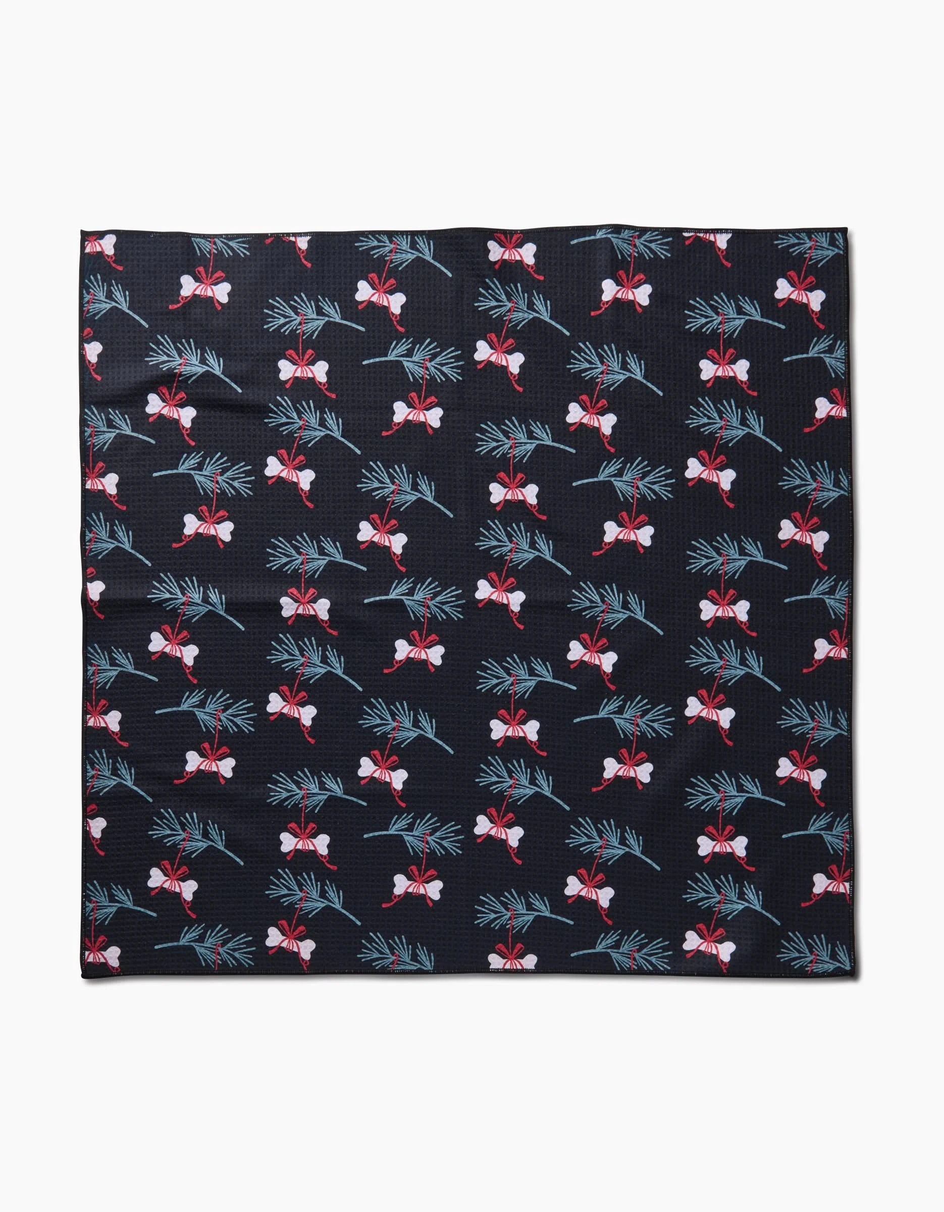 The Bones For Christmas black square dog towel by Charlie Rowan Designs is made from recycled fabric and features red and white flowers with green leaves evenly spaced across the surface.