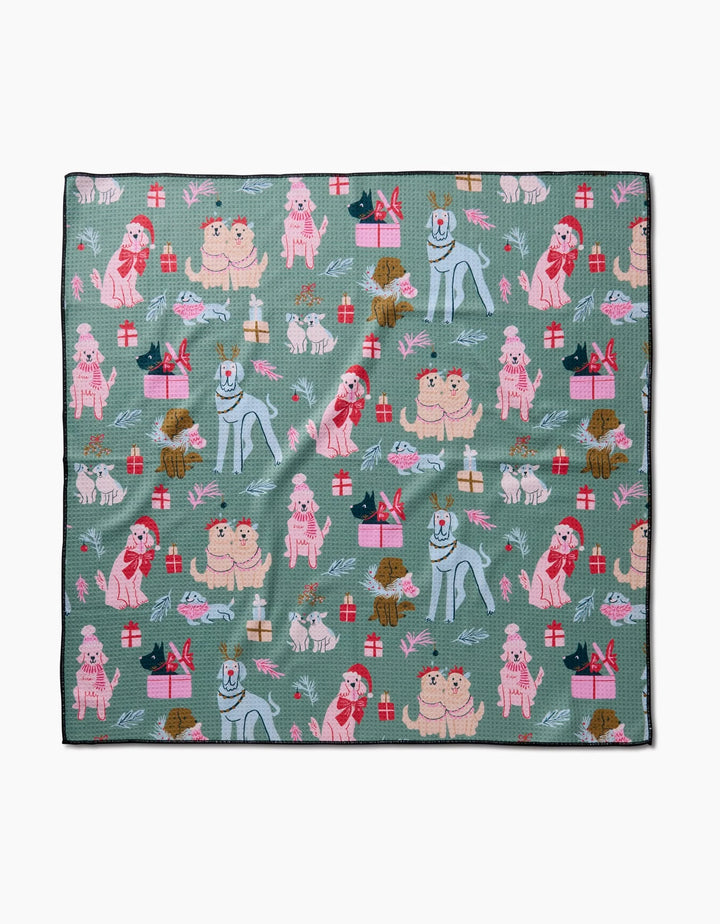 The Christmas Doggos blanket by Janna Sue Design is green, made from recycled materials, and features illustrated dogs, gifts, and bones in festive holiday colors and playful poses.