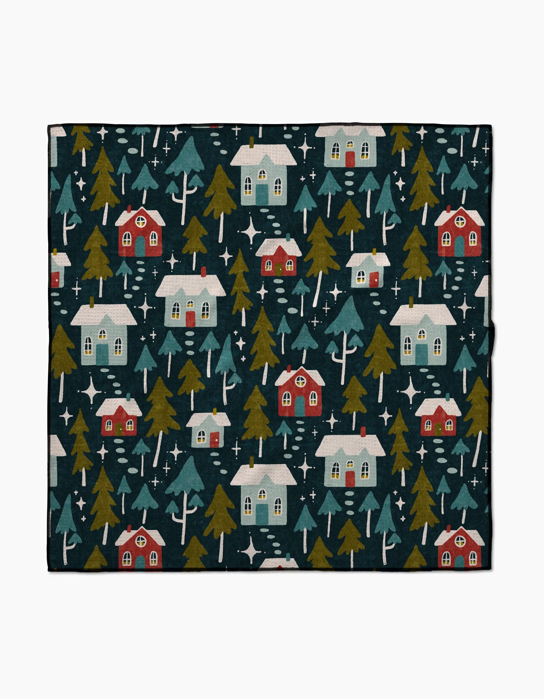 The Nico Dark blanket by Amy MacCready features red and white houses, snow-topped roofs, green trees, and snowflakes on a dark background—made from recycled materials for a cozy winter village vibe.