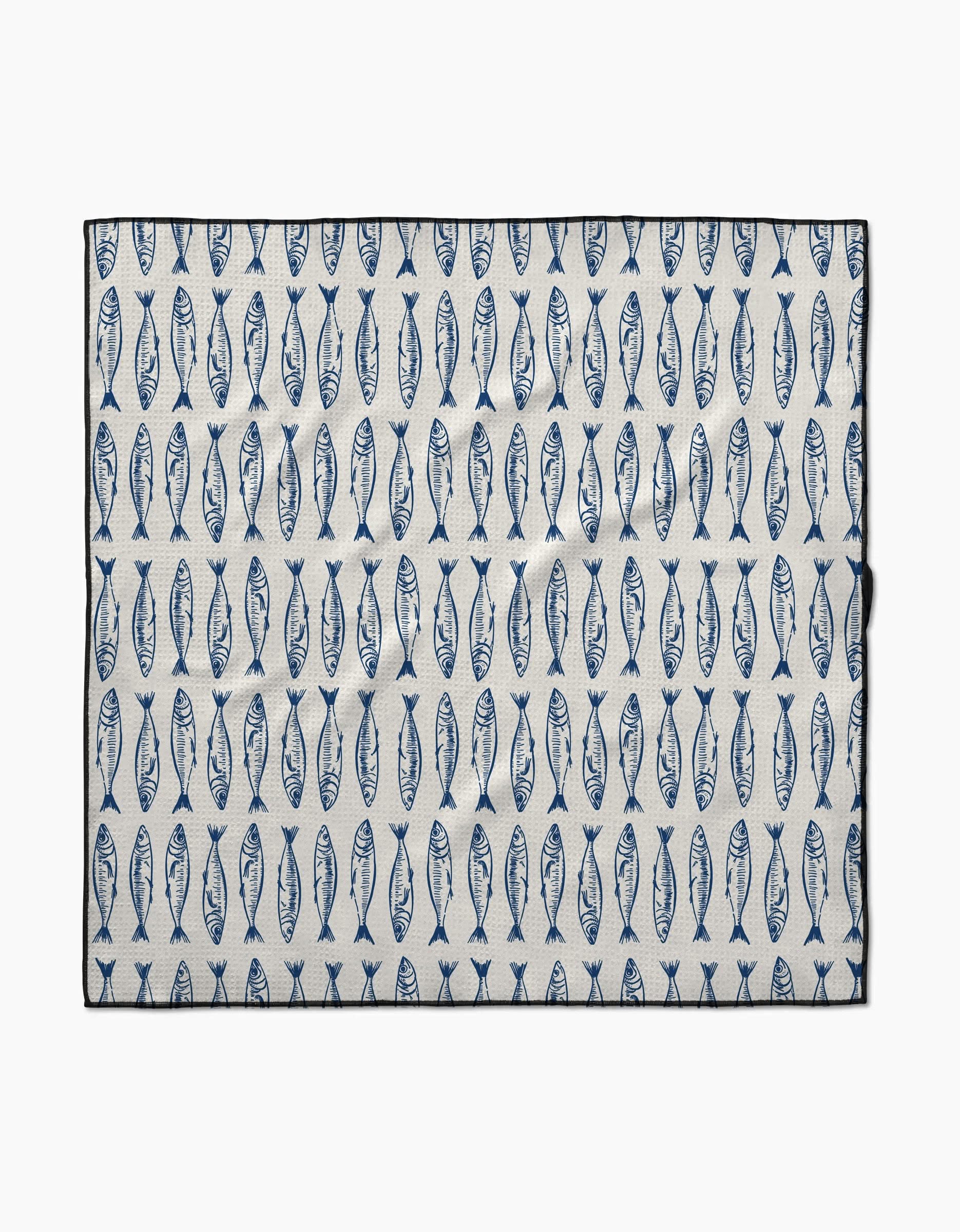 The Sardine Stripes mat by Hufton Studio is a rectangular white mat made from recycled materials, featuring rows of evenly spaced vertical blue fish and a black border.