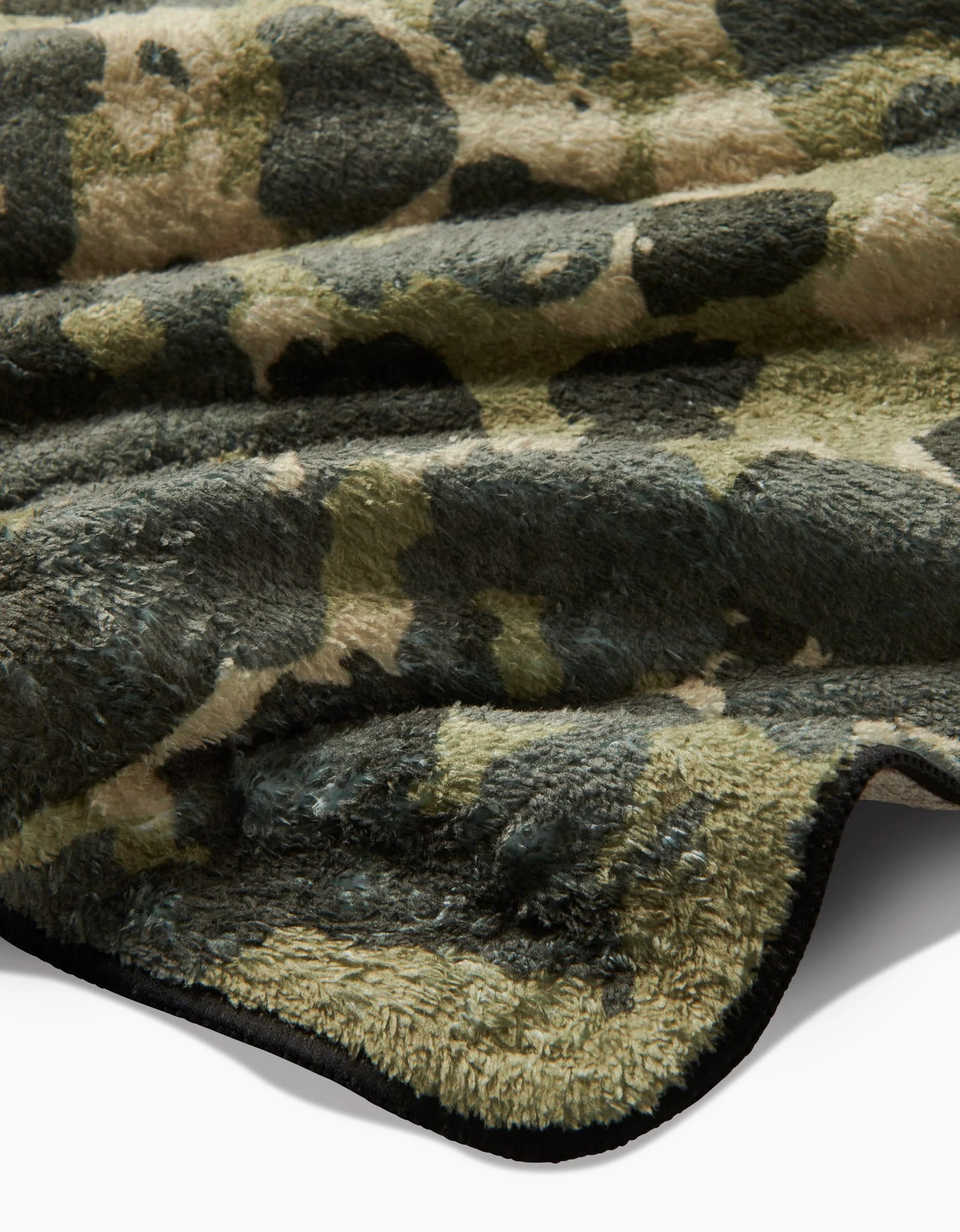 A close-up of Geometrys Camo dog towel shows its thick, ultra-absorbent, plush fabric with a green and beige camouflage pattern and a wavy texture for cozy comfort.
