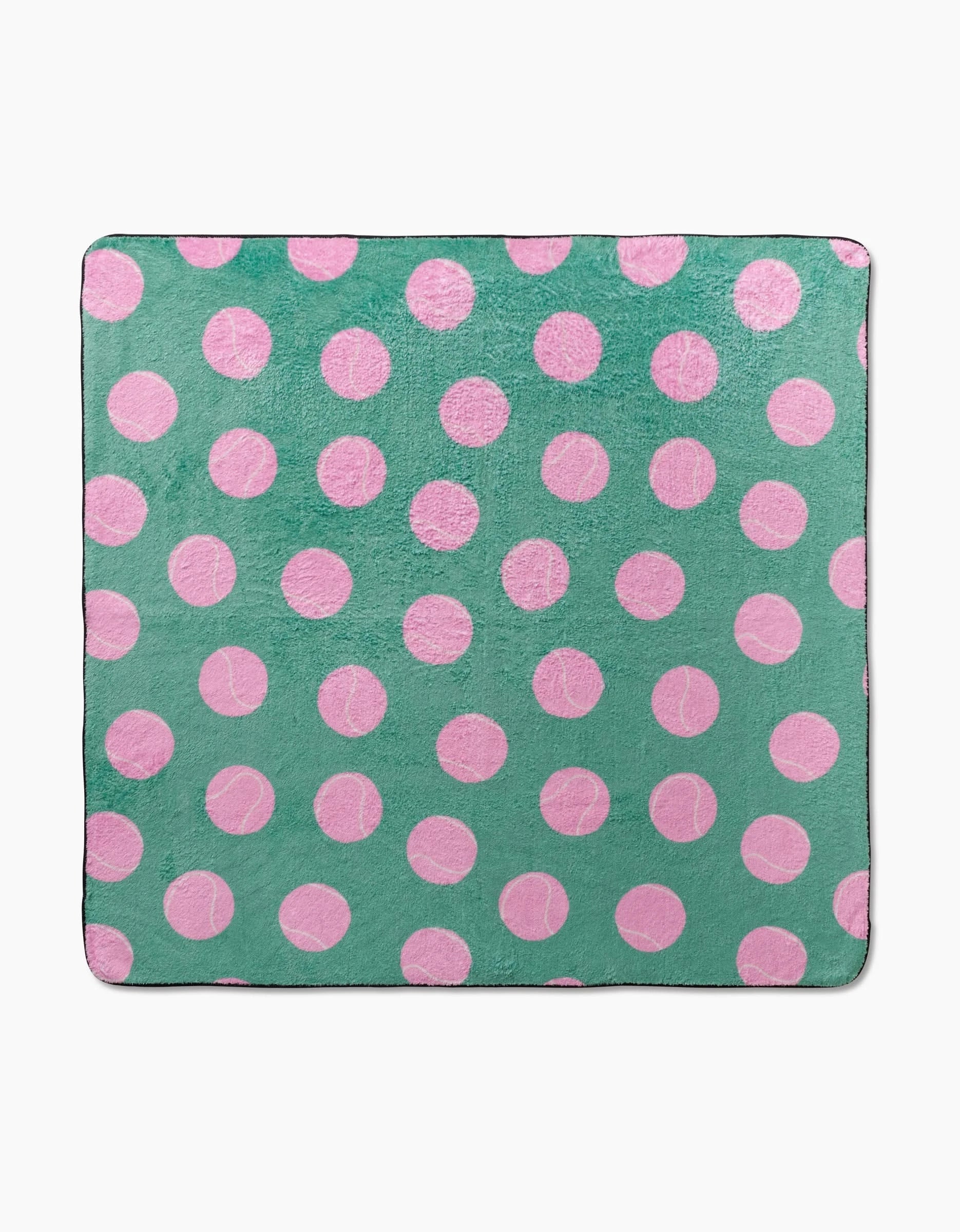 The Pink Ball dog towel from Geometry is a square, ultra-absorbent accessory made from recycled materials. It features evenly spaced pink polka dots on a solid green background for a fun, playful look.
