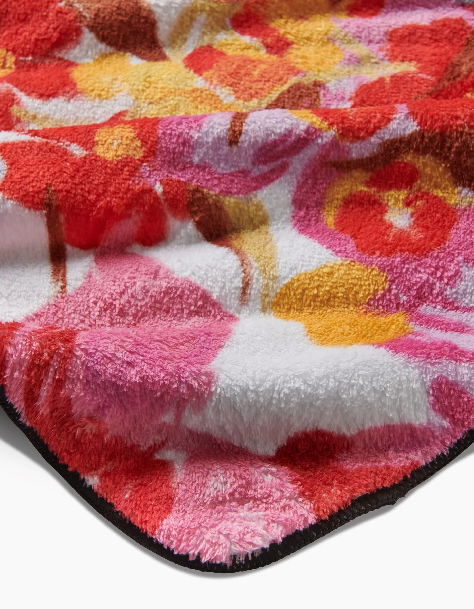 Close-up of the Geometry Pup Florals dog towel showing its ultra-absorbent, plush texture and vibrant floral pattern in pink, red, yellow, and white.