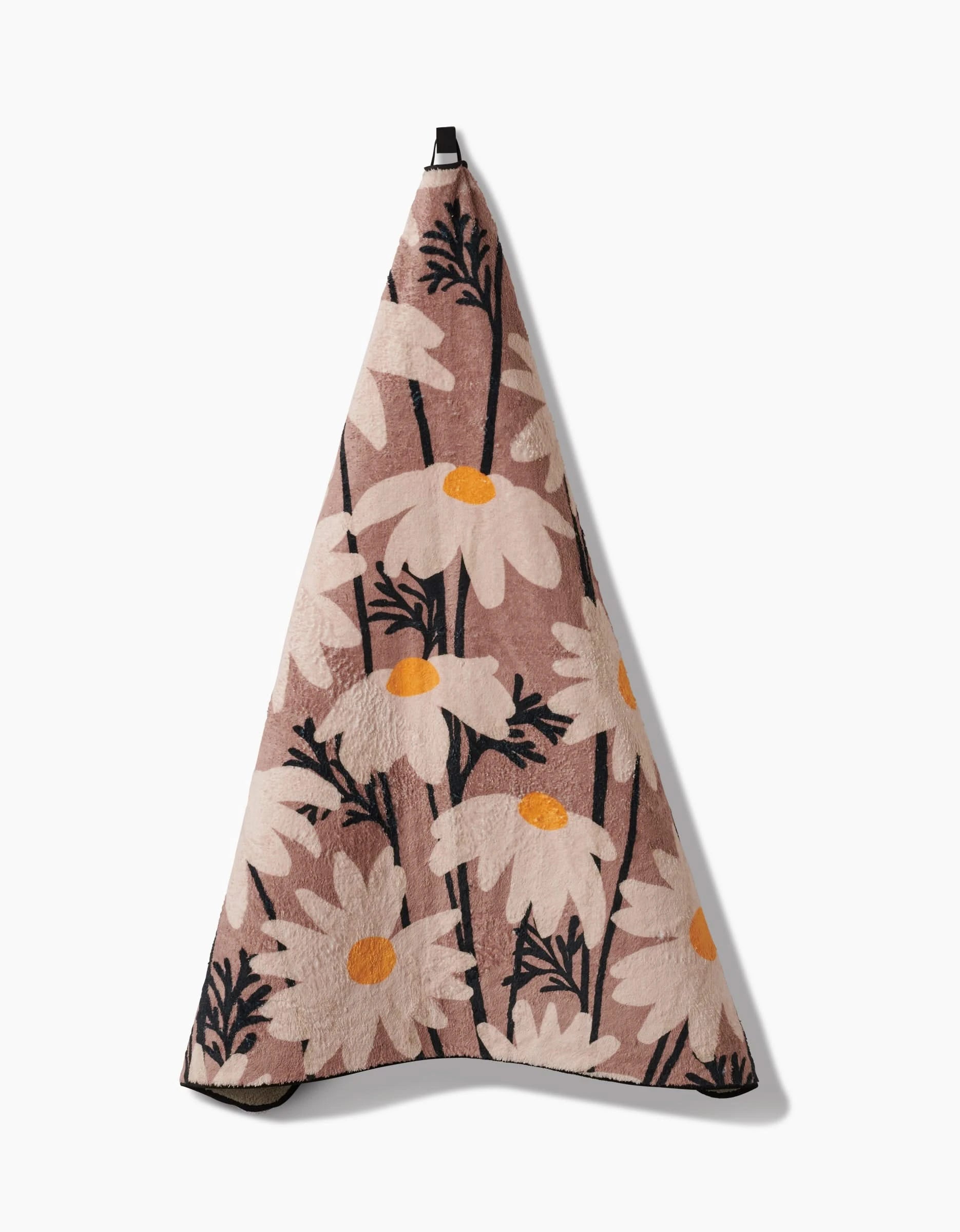 The Geometry Sweet Daisies towel is ultra-absorbent and features a floral pattern with large white daisies on a muted pink background—an eco-friendly, stylish hanging towel for your home.