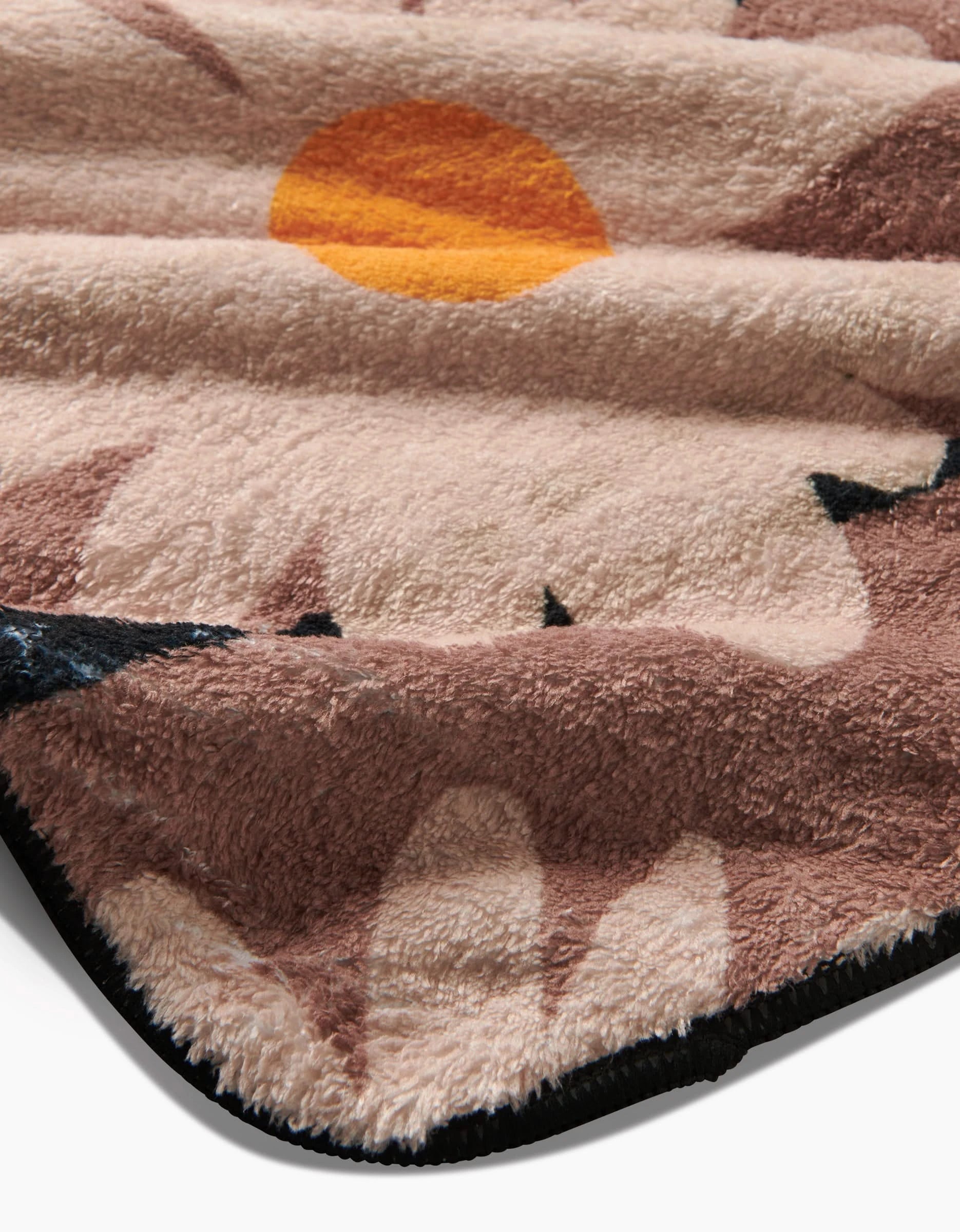 A close-up of the Sweet Daisies blanket by Geometry, featuring a soft, eco-friendly design with yellow-orange sun and brown mountain shapes, bordered in black—plush and ultra-absorbent like your favorite dog towel.