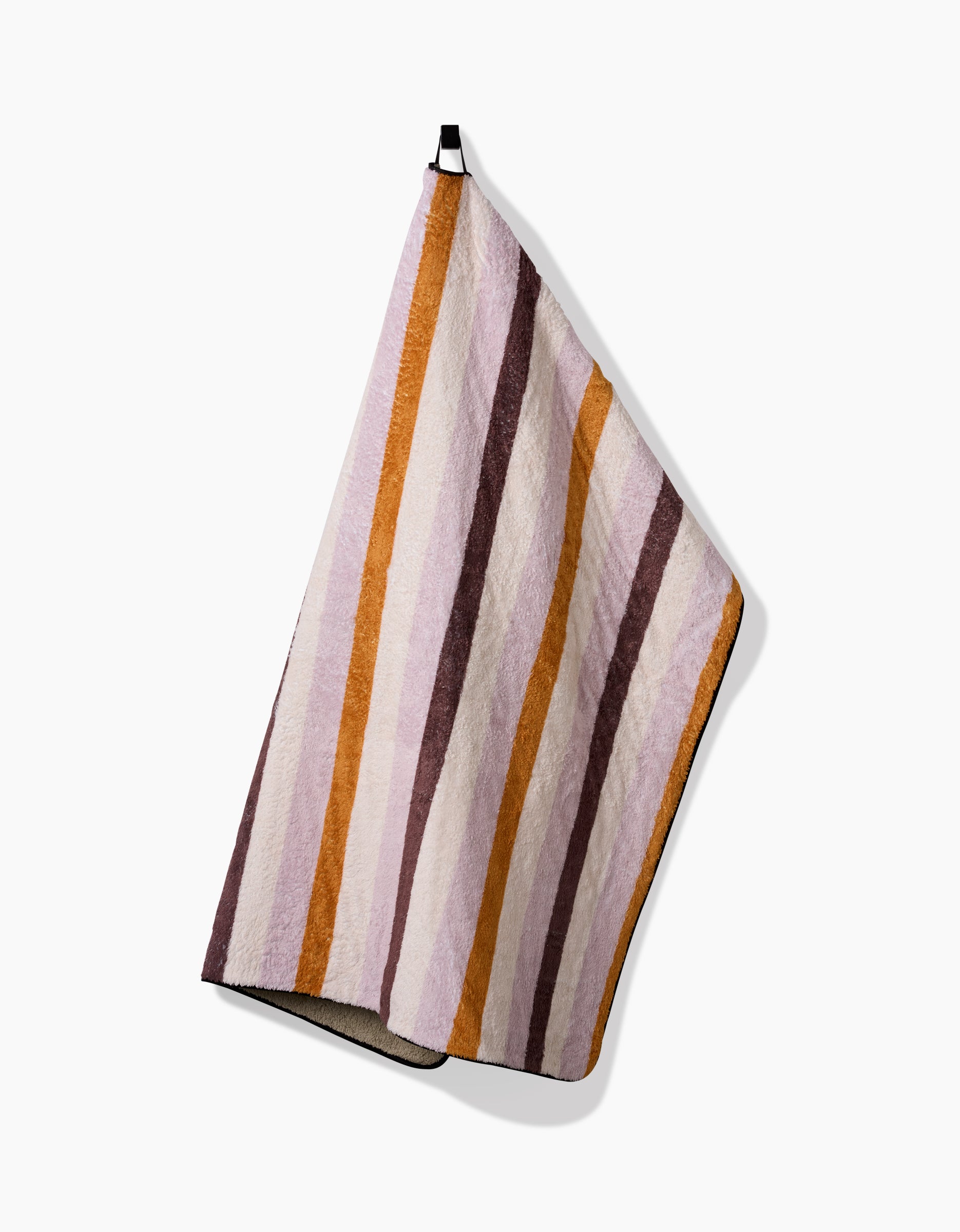 The Megan Roy Squirrels Stripe is a plush dog towel with vertical orange, brown, and cream stripes, shown hanging by a black-and-white loop against a white background.