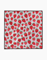 The Geometry Strawberry Sniff Paw Towel features ultra-absorbent Geoweave fabric with a repeating red strawberry and green leaf pattern on white, finished with a black border. The towel appears slightly wrinkled.