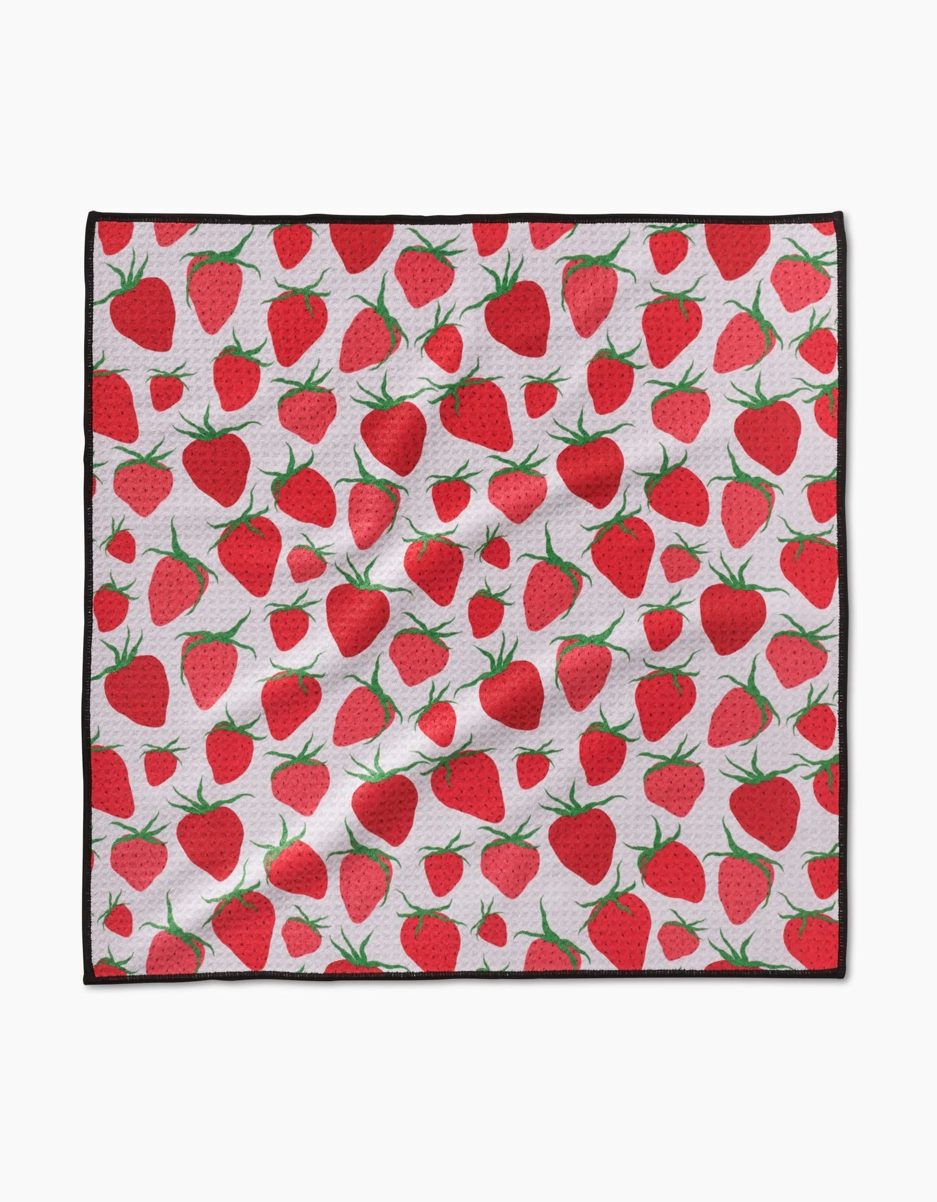 The Geometry Strawberry Sniff Paw Towel features ultra-absorbent Geoweave fabric with a repeating red strawberry and green leaf pattern on white, finished with a black border. The towel appears slightly wrinkled.