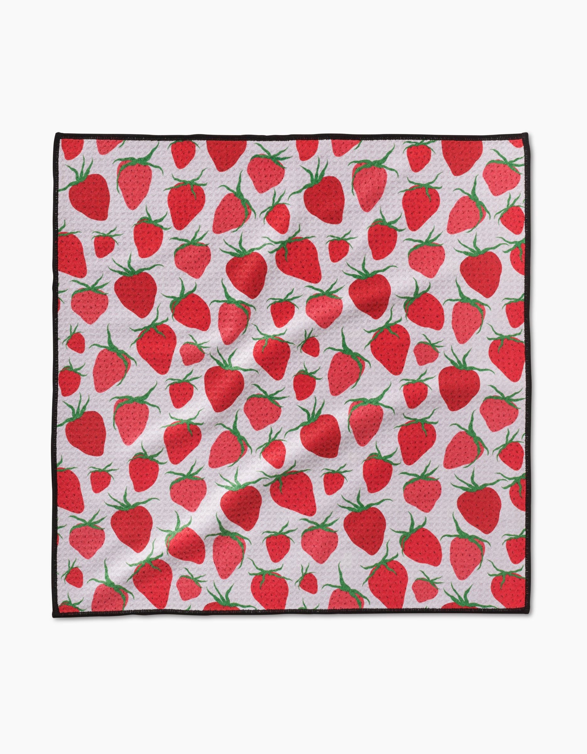 The Geometry Strawberry Sniff Paw Towel features ultra-absorbent Geoweave fabric with a repeating red strawberry and green leaf pattern on white, finished with a black border. The towel appears slightly wrinkled.