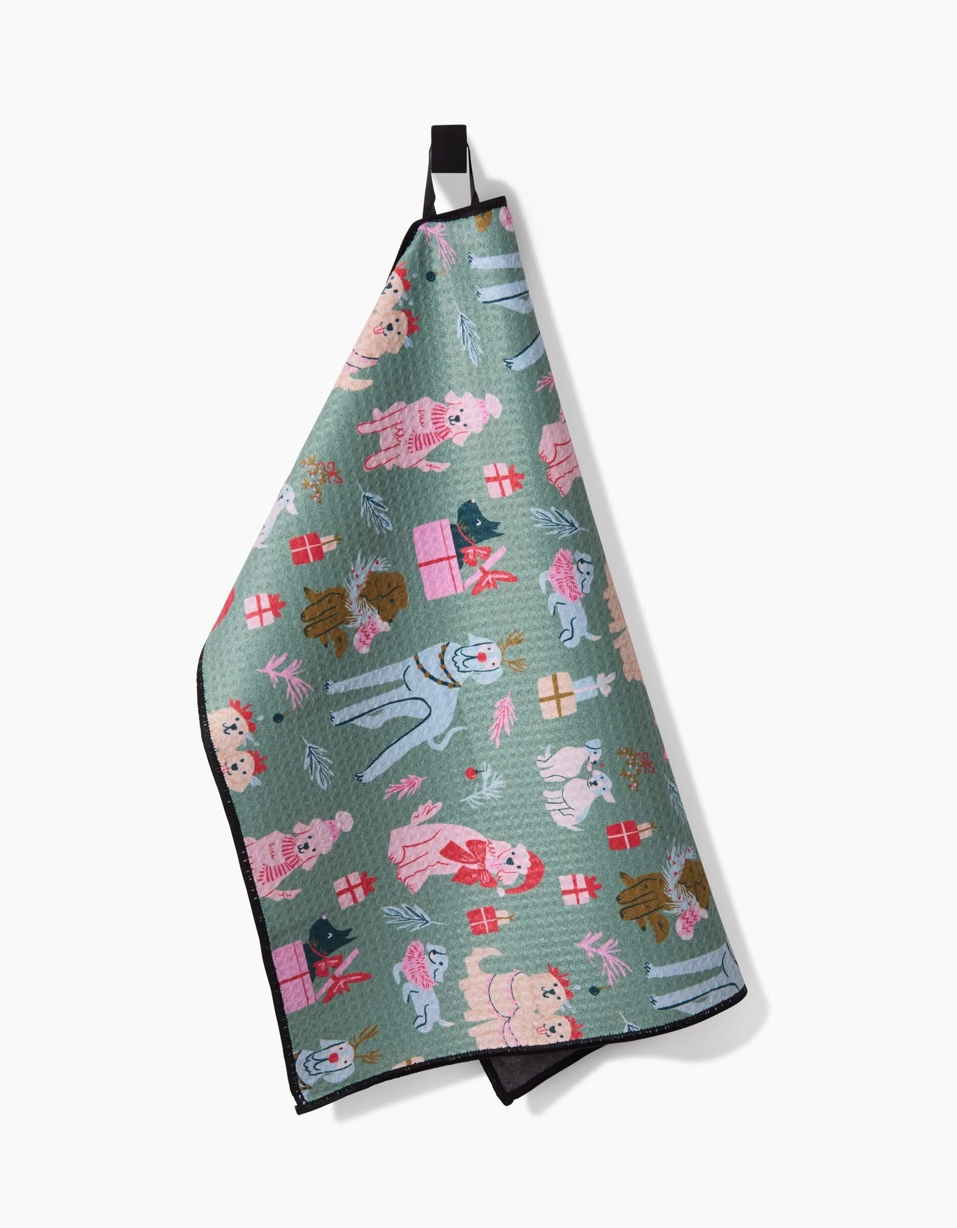 The Christmas Doggos towel by Janna Sue Design is a green recycled PET towel with a black loop, decorated with poodles, presents, and festive accents in pink, red, blue, and brown.
