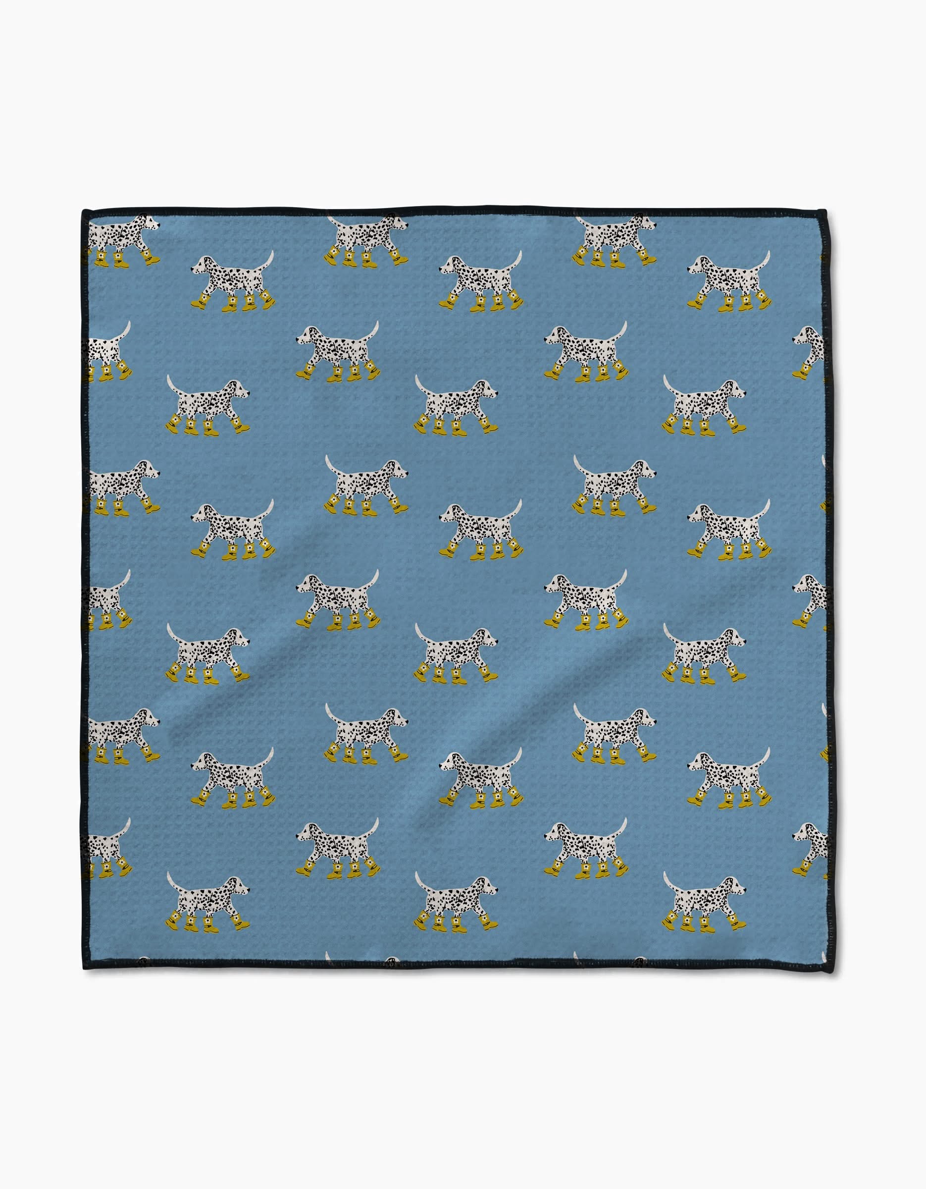 The Geometry Dalmatian In Boots Blue Paw Towel features a blue Geoweave cloth with white spotted dogs in yellow boots, arranged in rows facing both ways, and finished with black borders for a stylish touch.