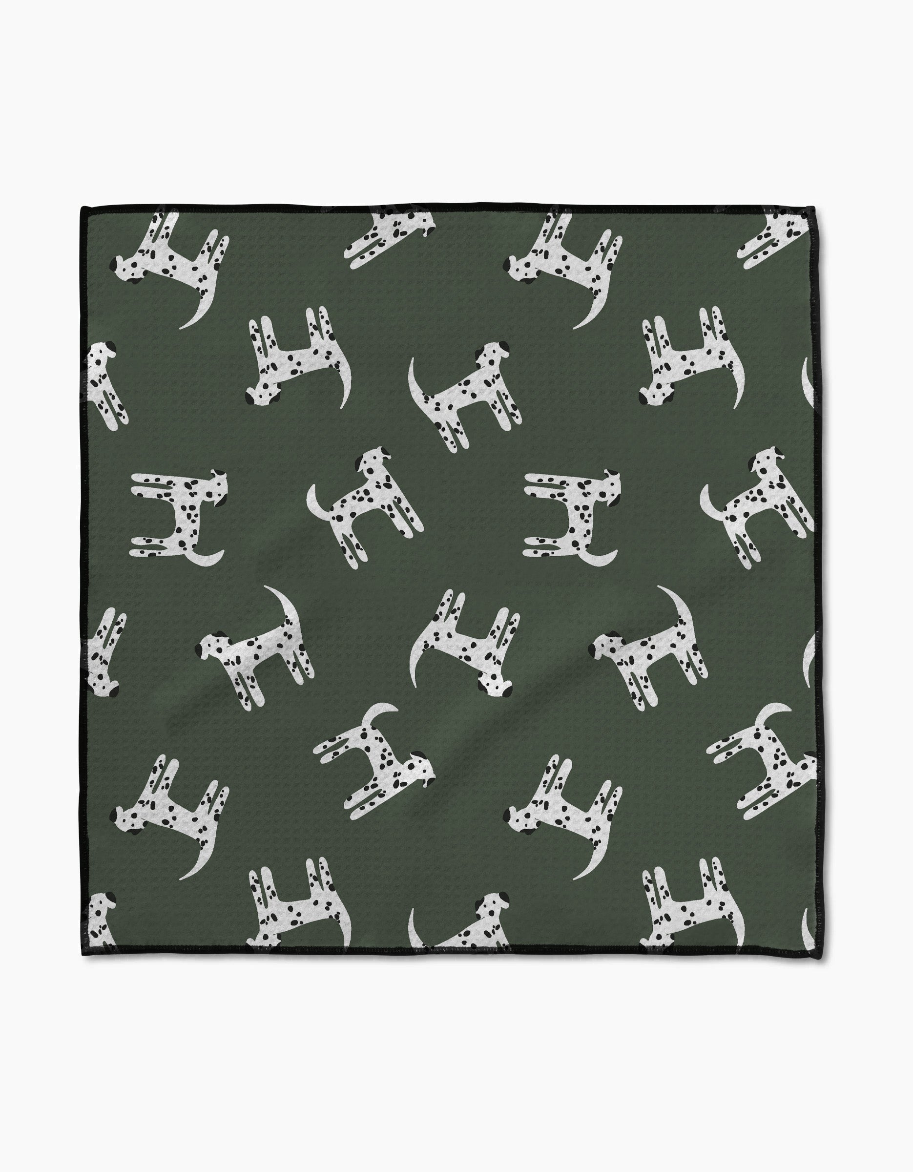 The Coit Creative “Dalmation Dogs” Paw Towel features a green Geoweave fabric with white Dalmatian dog patterns, each with unique black spots, and a chic black border for style and absorbency.