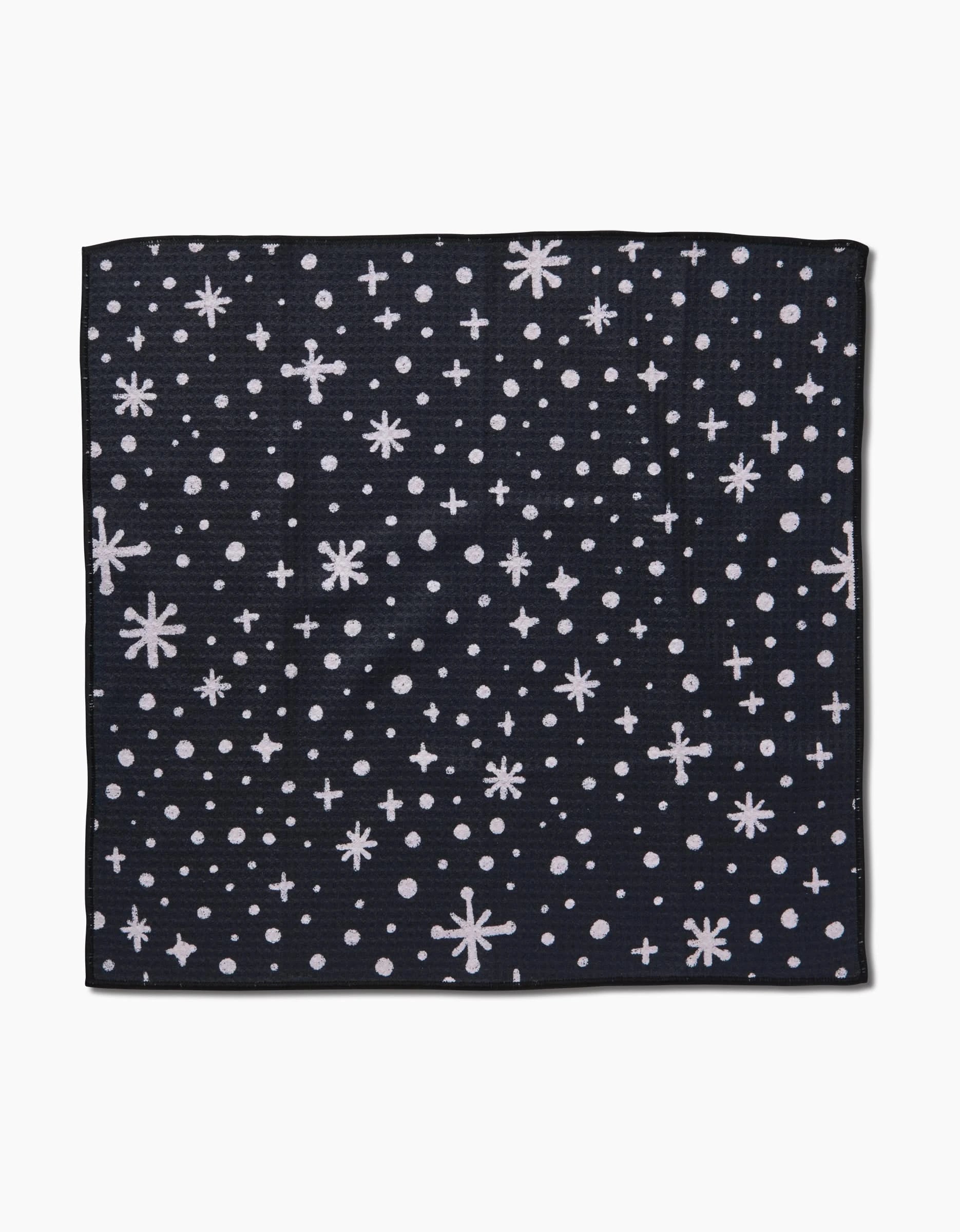 The Estrella Paw Towel by Amy MacCready features a dark square design with white stars, dots, and plus signs—resembling a night sky—making it an ultra-absorbent and stylish choice for your dog.