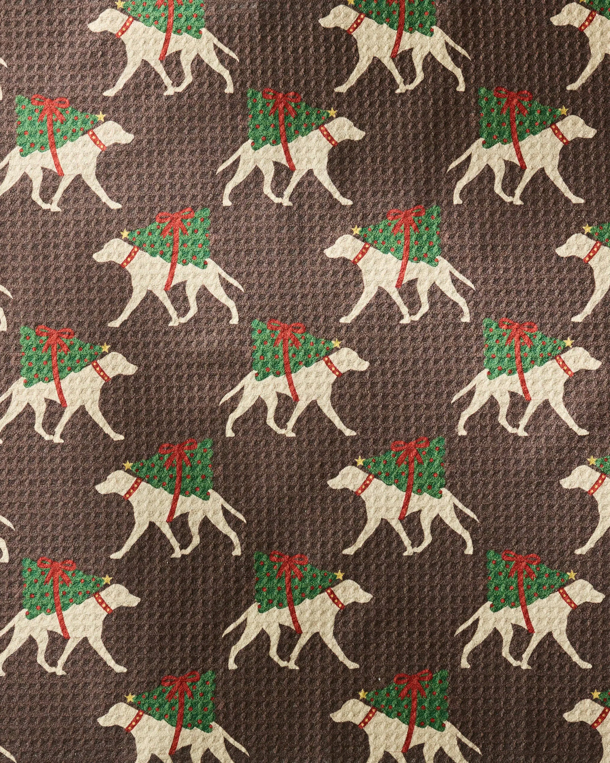 Celebrate every drying moment with Geometry’s “Holiday Helpers” dog towel—a festive design featuring white dogs sporting red bows and toting green Christmas trees on their backs, all set against a brown textured background. This ultra-absorbent, recycled pet towel is perfect for bringing holiday cheer to you and your pup!.