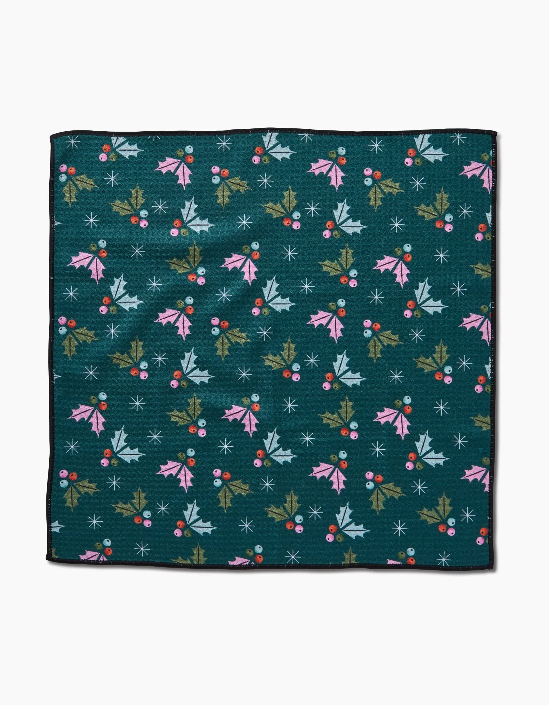 The Megan Roy “Holly Berries” Paw Towel features a festive pattern of pink, green, and blue holly leaves, red berries, and white snowflakes on dark green—perfect for holiday celebrations.