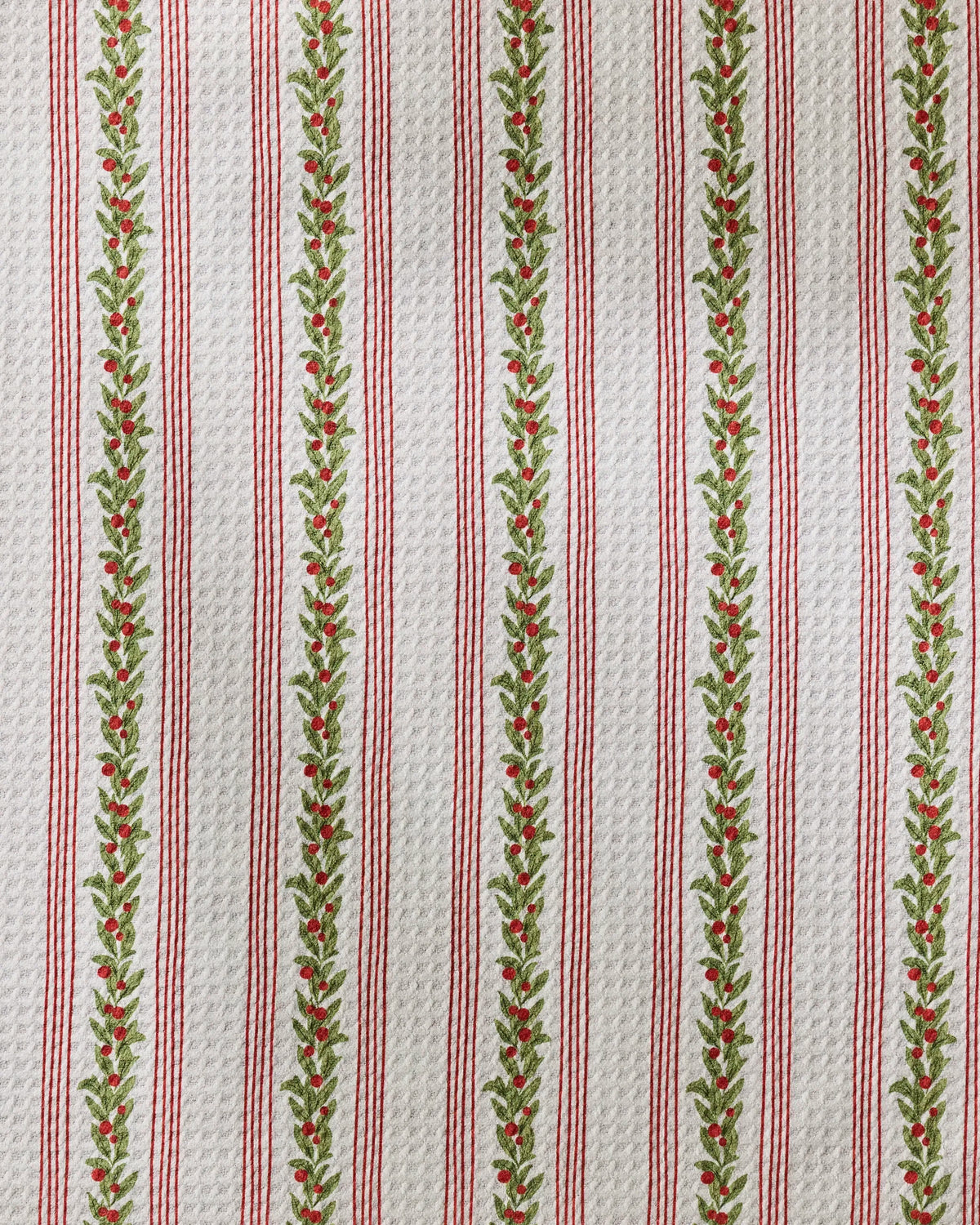Geometry’s Holly Vine dog towel features white textured fabric adorned with vertical red stripes and green leafy vines accented by small red berries in a festive, repeating holiday pattern—making it the perfect ultra-absorbent towel to add seasonal charm to your pet’s routine.