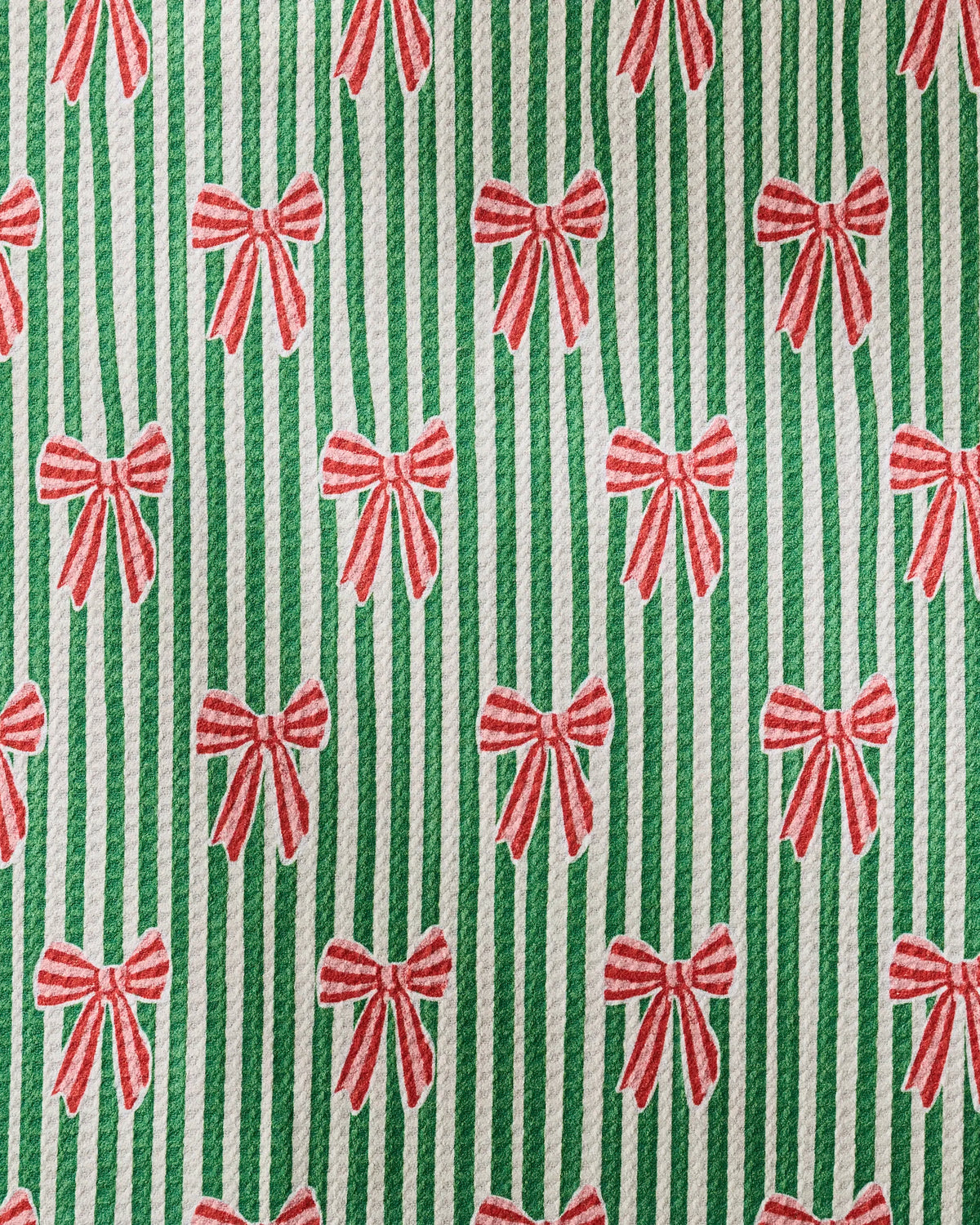 Featuring Green and white vertical stripes accented by a repeating pattern of red bows, Geometry’s “Ribbon Toss” design creates a festive, holiday-themed background—perfect for highlighting your ultra-absorbent dog towel or recycled pet towel.