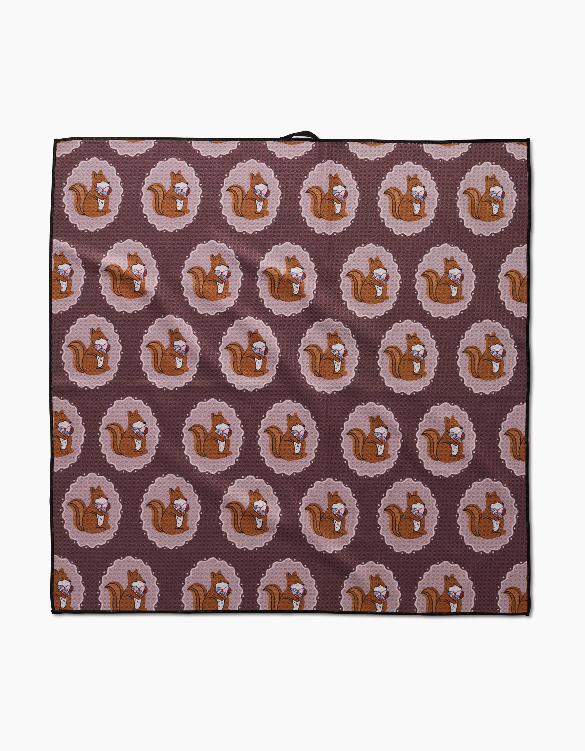The Squirrels Brown Paw Towel by Megan Roy features cartoon brown squirrels with acorns in scalloped circles on a dark mauve background, made from ultra-absorbent Geoweave fabric.