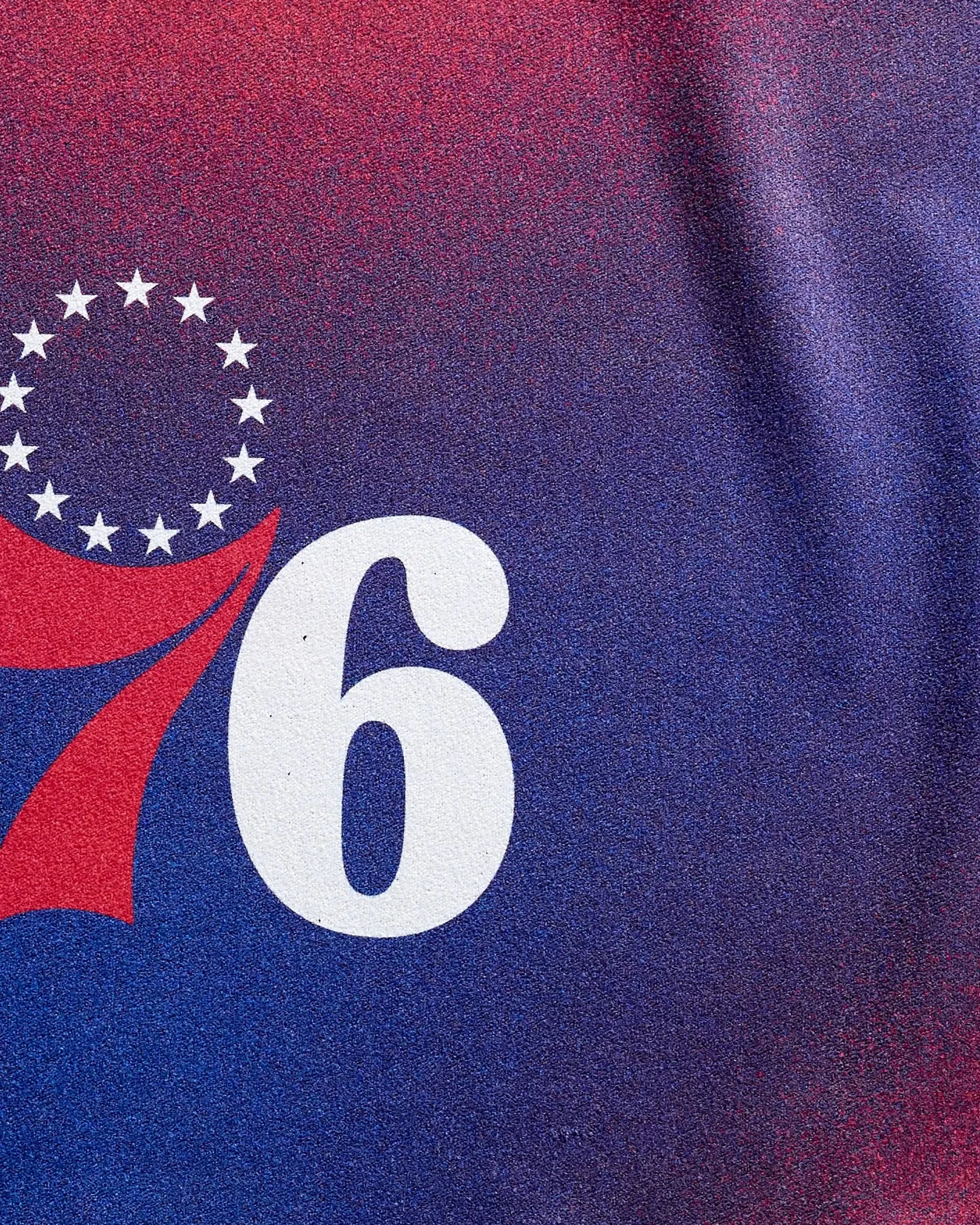 Close-up of the NBALAB x Geometry 76ers Fade towel, showcasing the number 76 in white and red, encircled by 13 stars on a blue and red gradient—ideal inspiration for any NBA fitness accessory.