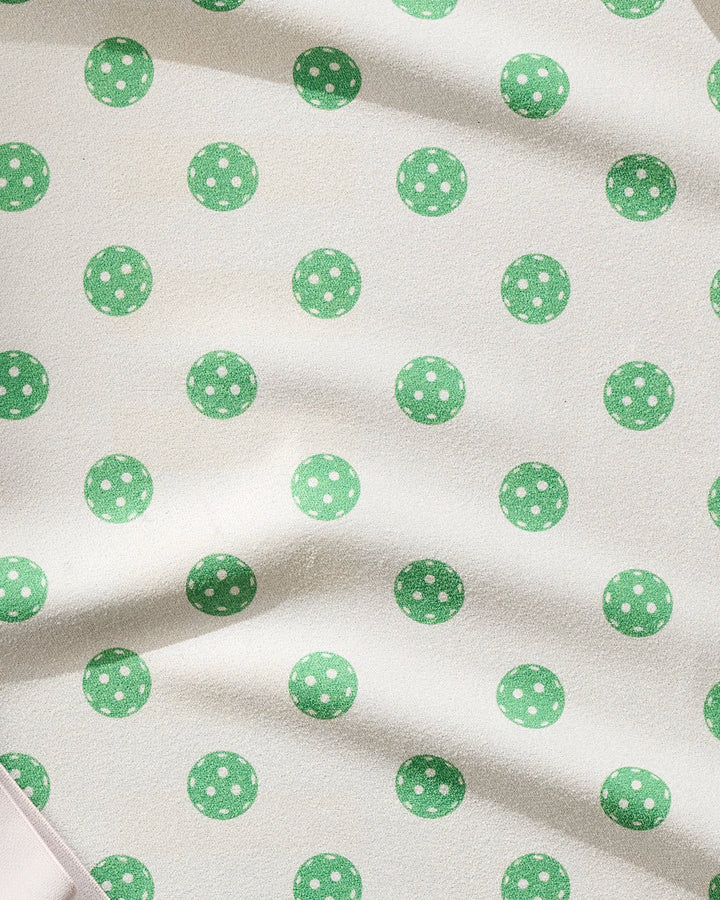The Geometry Ace towel features a cream base with ultra-absorbent, fast-drying fabric and green polka dots accented by subtle white spots. Soft folds and shadows emphasize its textured look—ideal for workouts or fitness routines.