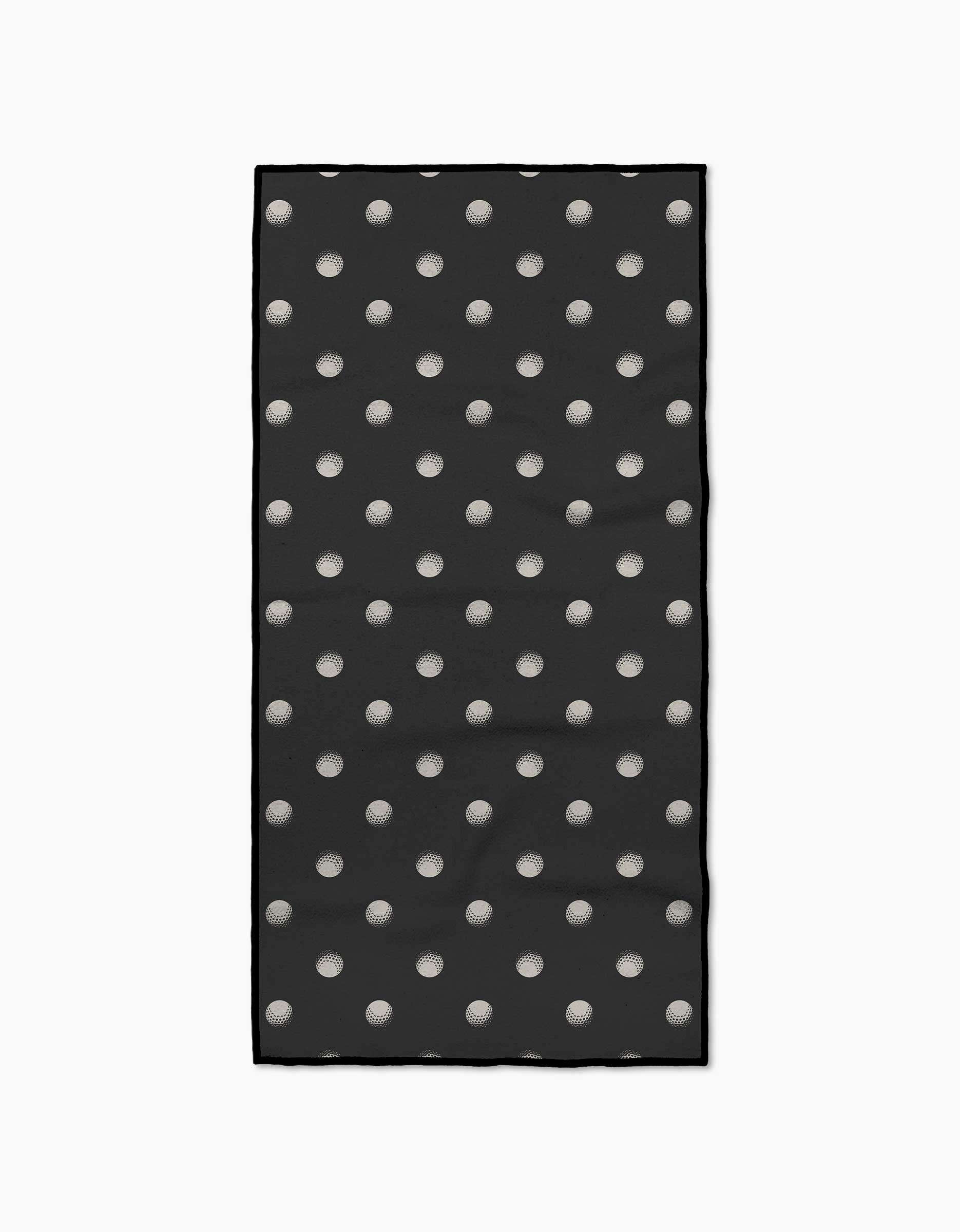 Geometry’s Birdie towel is a black rectangular fitness towel with evenly spaced white polka dots, bordered by a thin black line. Crafted from recycled materials, it’s ultra-absorbent and shown on a plain white background.