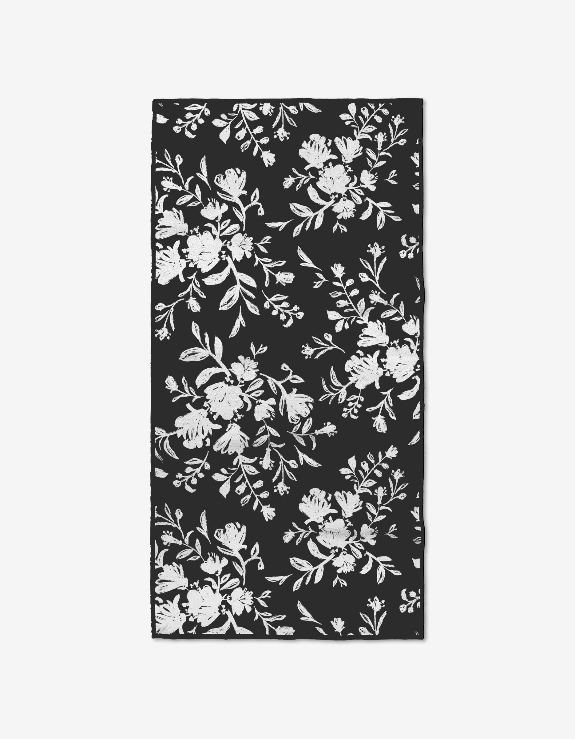 The Botanical Silhouettes Charcoal by Danelys Sidron is a rectangular fitness towel with a black background and white floral silhouettes, crafted from recycled materials for an elegant, eco-friendly touch.