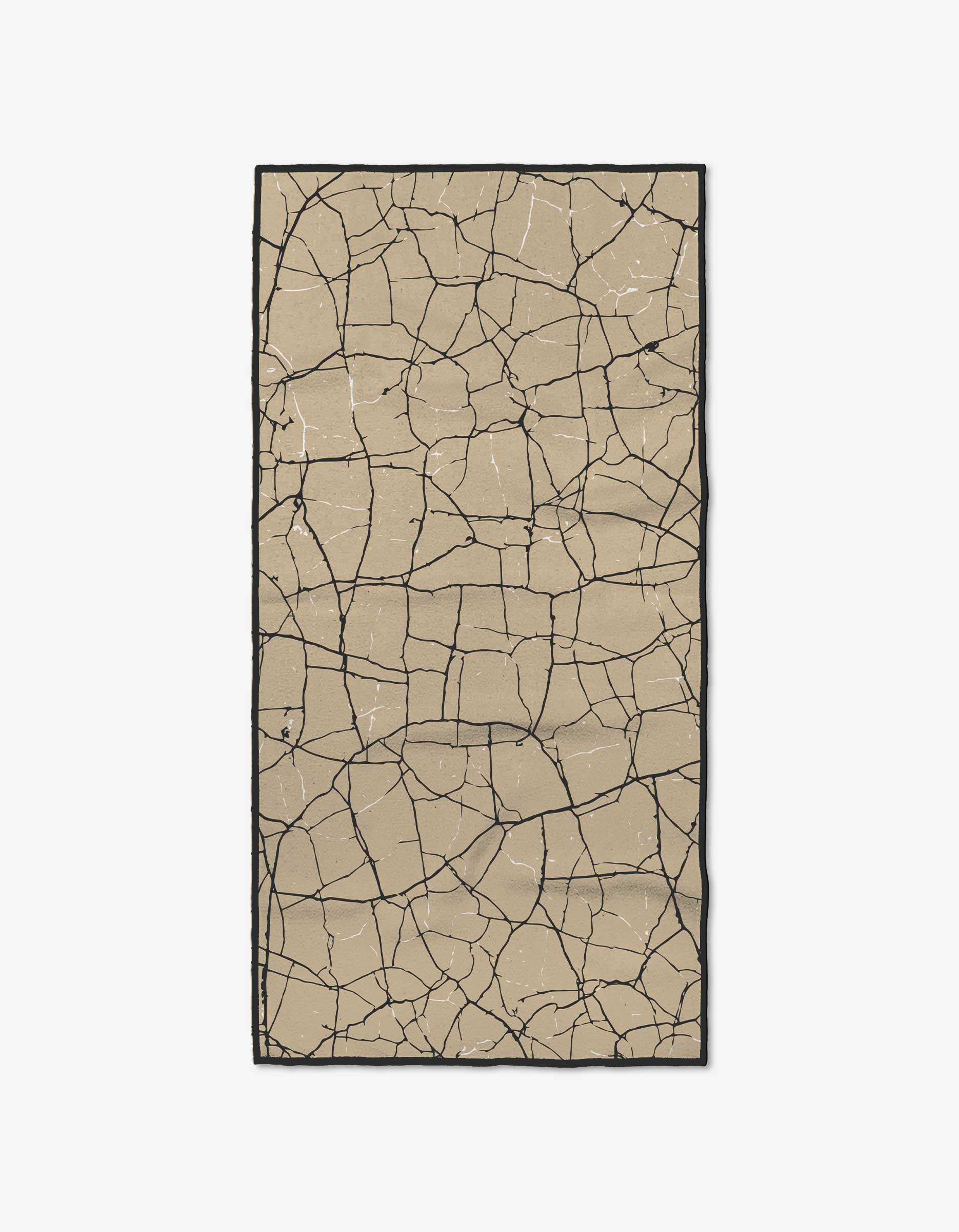 The GEOMETRY Break Through rug features a rectangular beige design with an irregular black crackle pattern on white, inspired by cracked earth and crafted from recycled materials for sustainability.