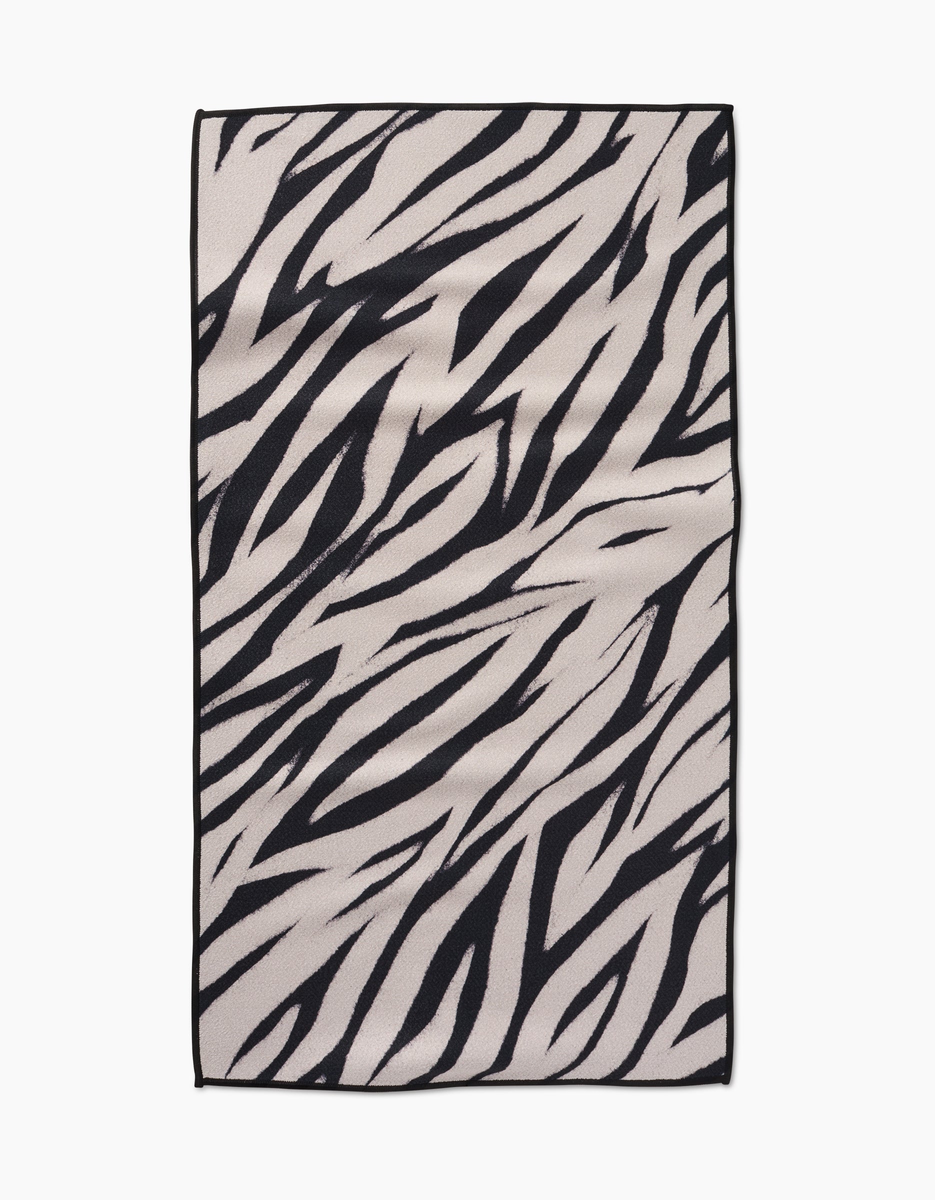 The Chase rug by GEOMETRY features a rectangular shape with bold, irregular black zebra stripes on a light background and is crafted from recycled materials.