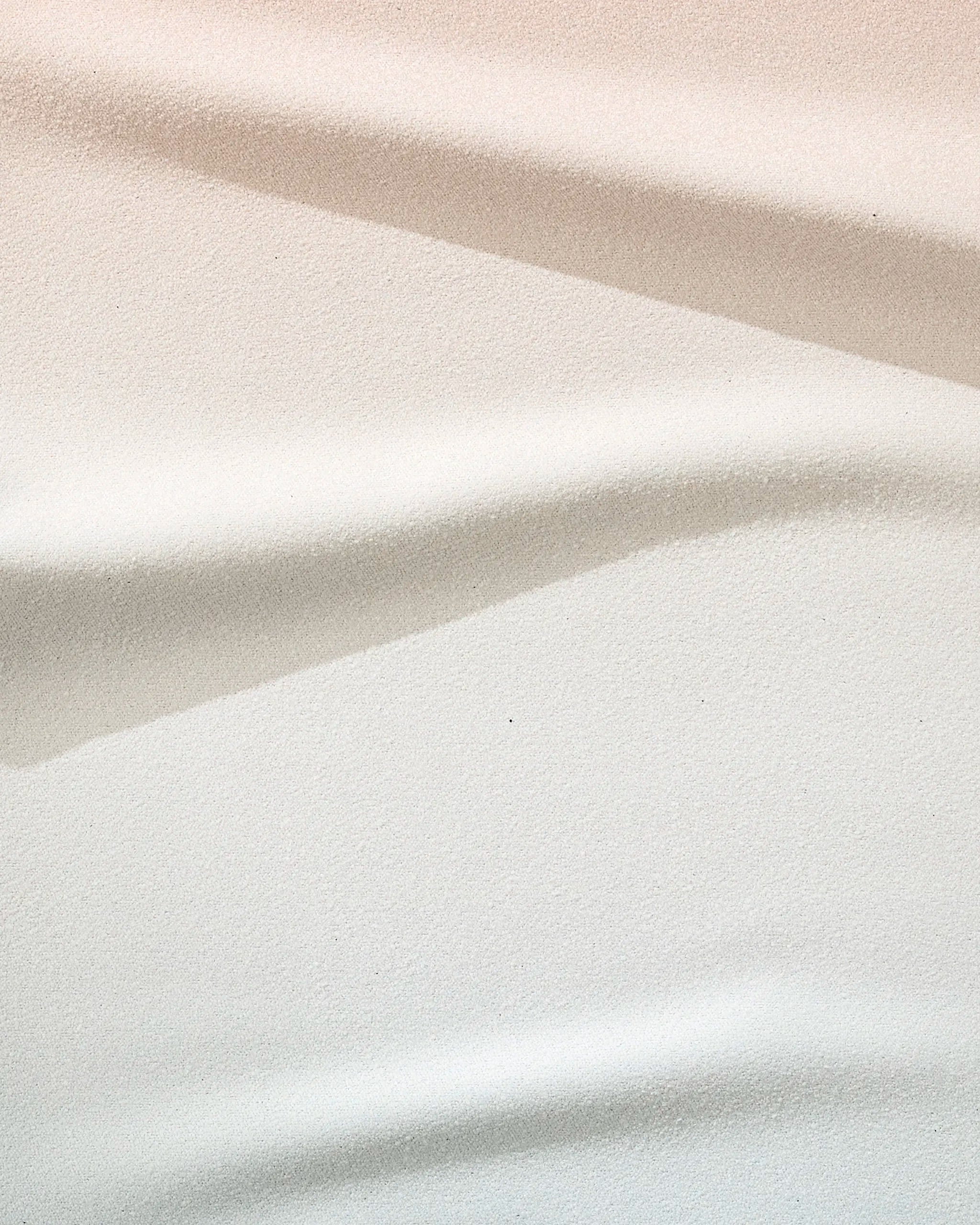 Close-up of the GEOMETRY Core towel in soft white, beige, and light grey tones with striped folds—ultra-absorbent and crafted from recycled materials.