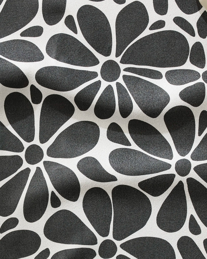 The GEOMETRY Cute Flowers fitness towel features a bold black-and-white abstract floral pattern with large black flowers on white. Made from recycled materials, this ultra-absorbent towel has a slightly wrinkled look for added texture.