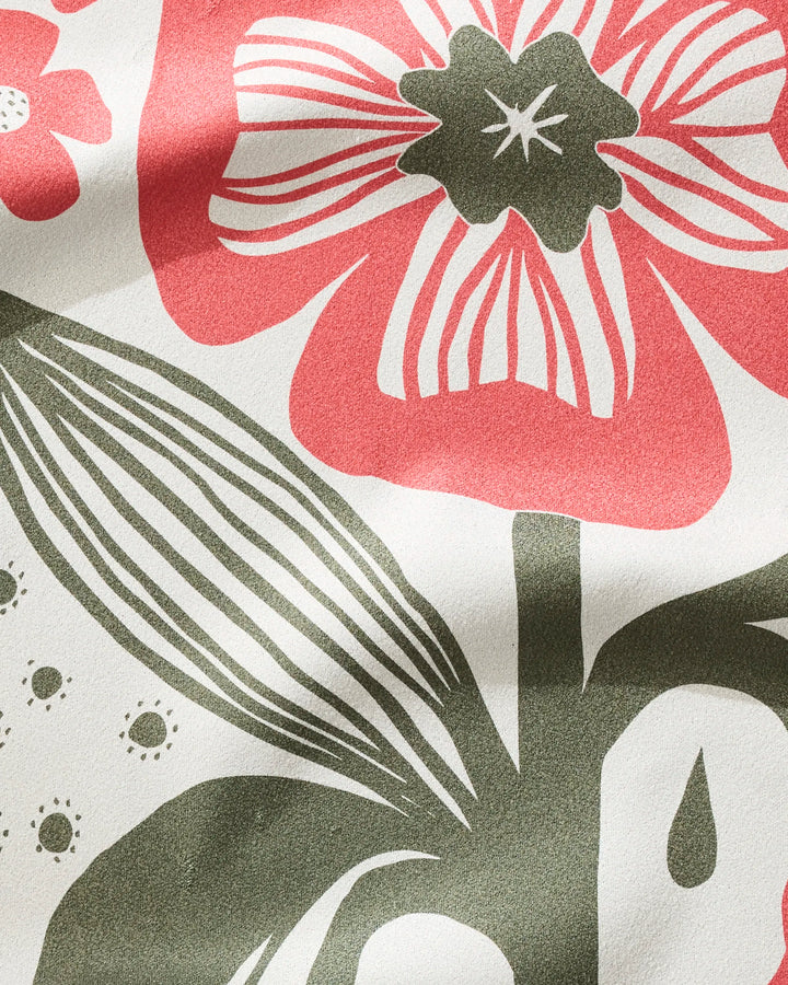A close-up of the ultra-absorbent Flower Stamp fabric by Ash Cascade, showcasing large red flowers and green leaves on a white background with visible texture and shadows.