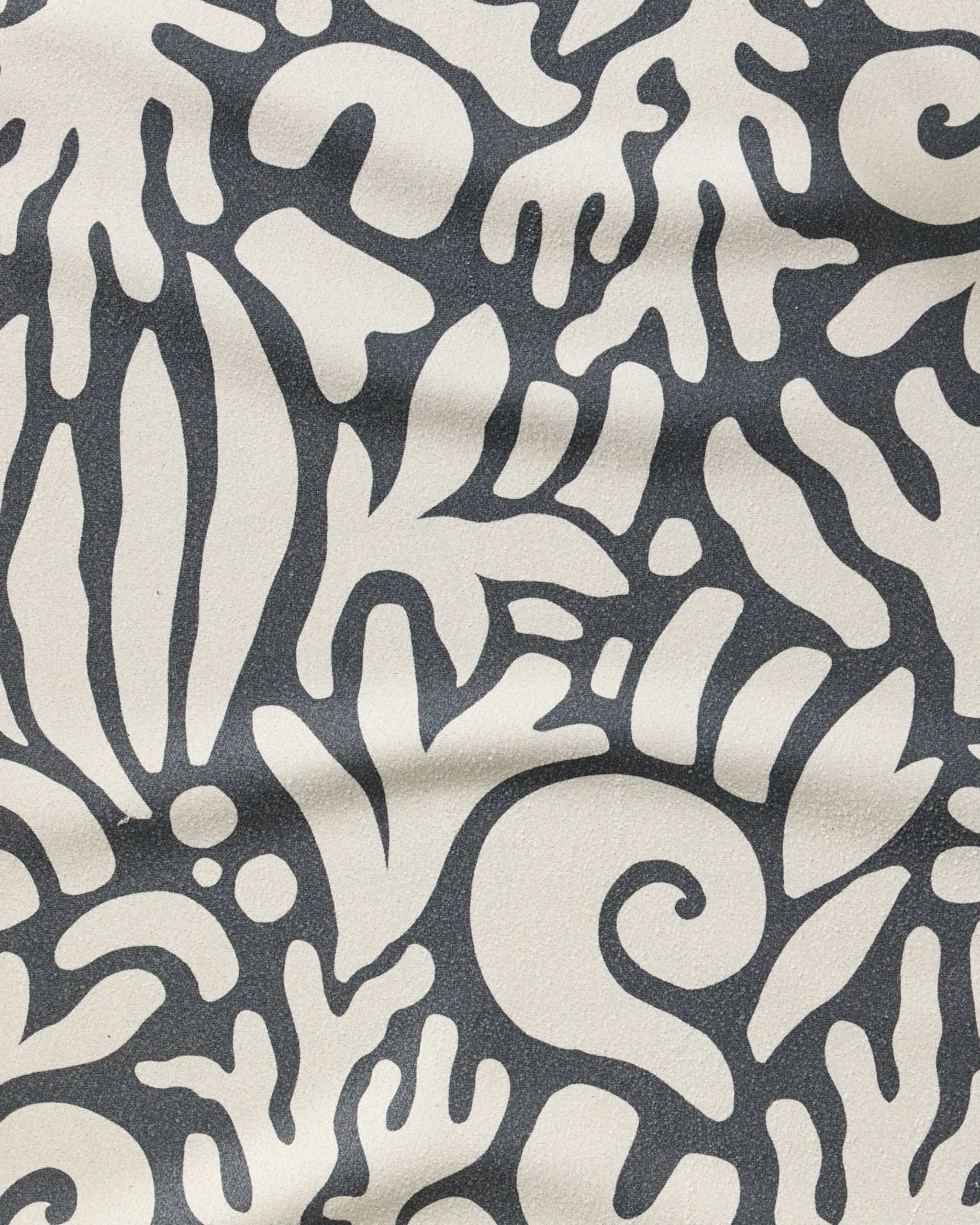Inkwell Reef by Geometry features black, coral-like organic shapes on a textured off-white background—an ultra-absorbent, stylish fitness towel made from recycled materials.