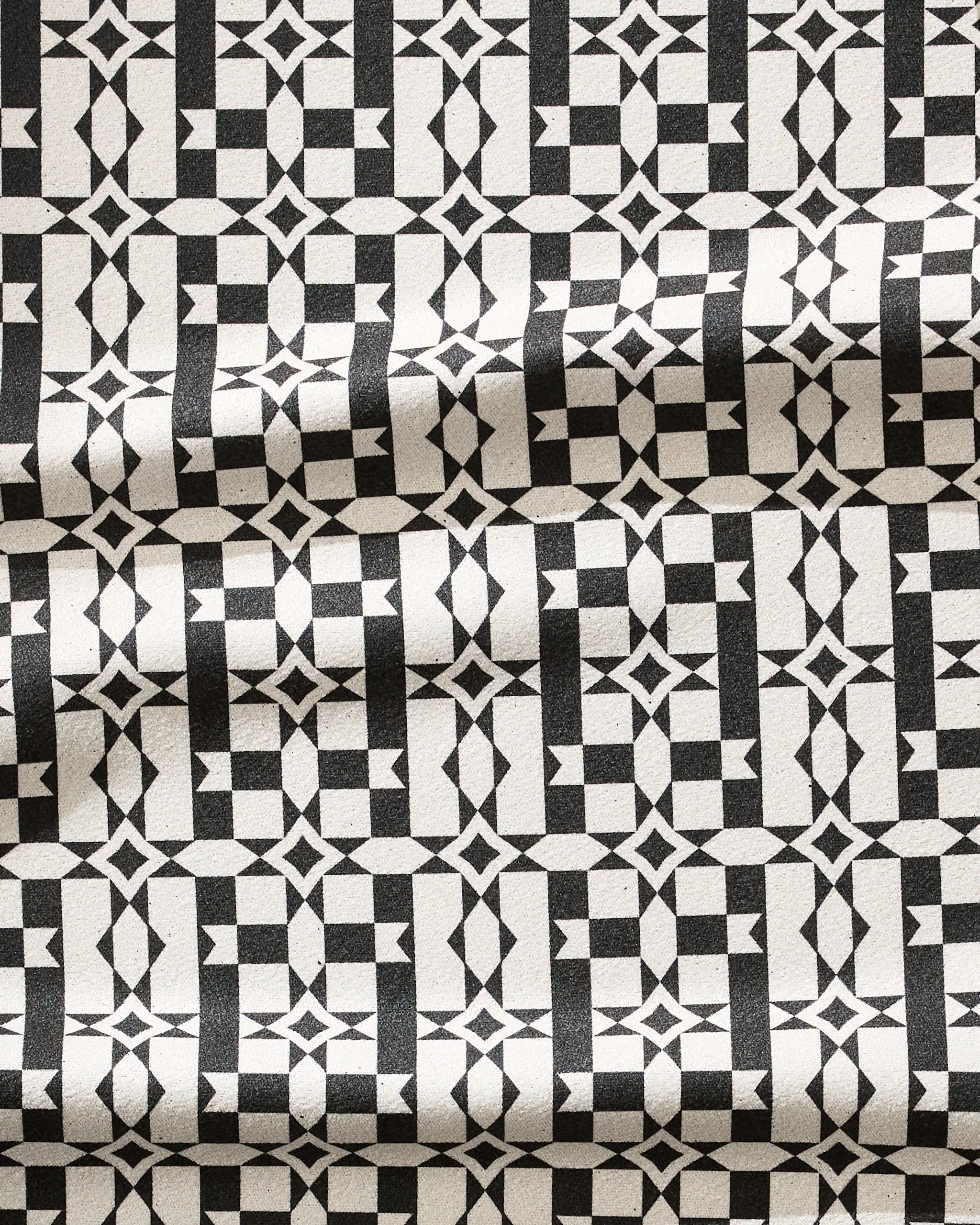 The Geometry Intermission towel features a black and white geometric pattern with repeating squares, stars, and diamonds on ultra-absorbent, quick-drying fabric—ideal for fitness routines.