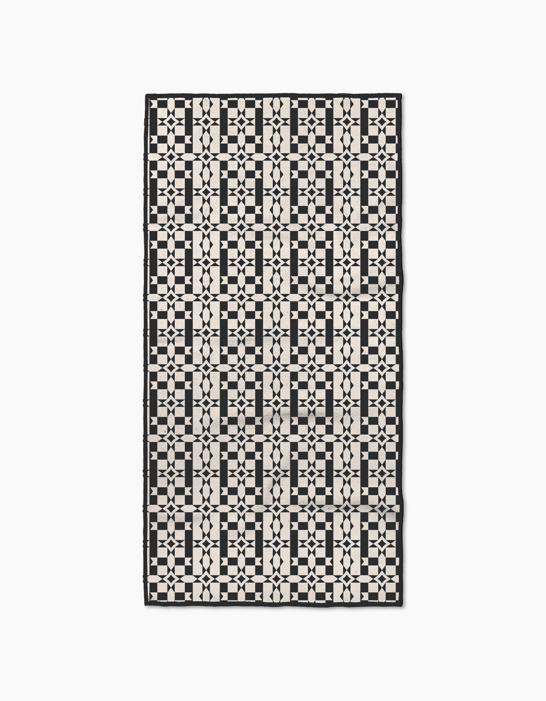 The Intermission rug by Geometry is a rectangular piece made from recycled materials, featuring a modern, symmetrical black and white geometric pattern of squares, circles, and intersecting lines.
