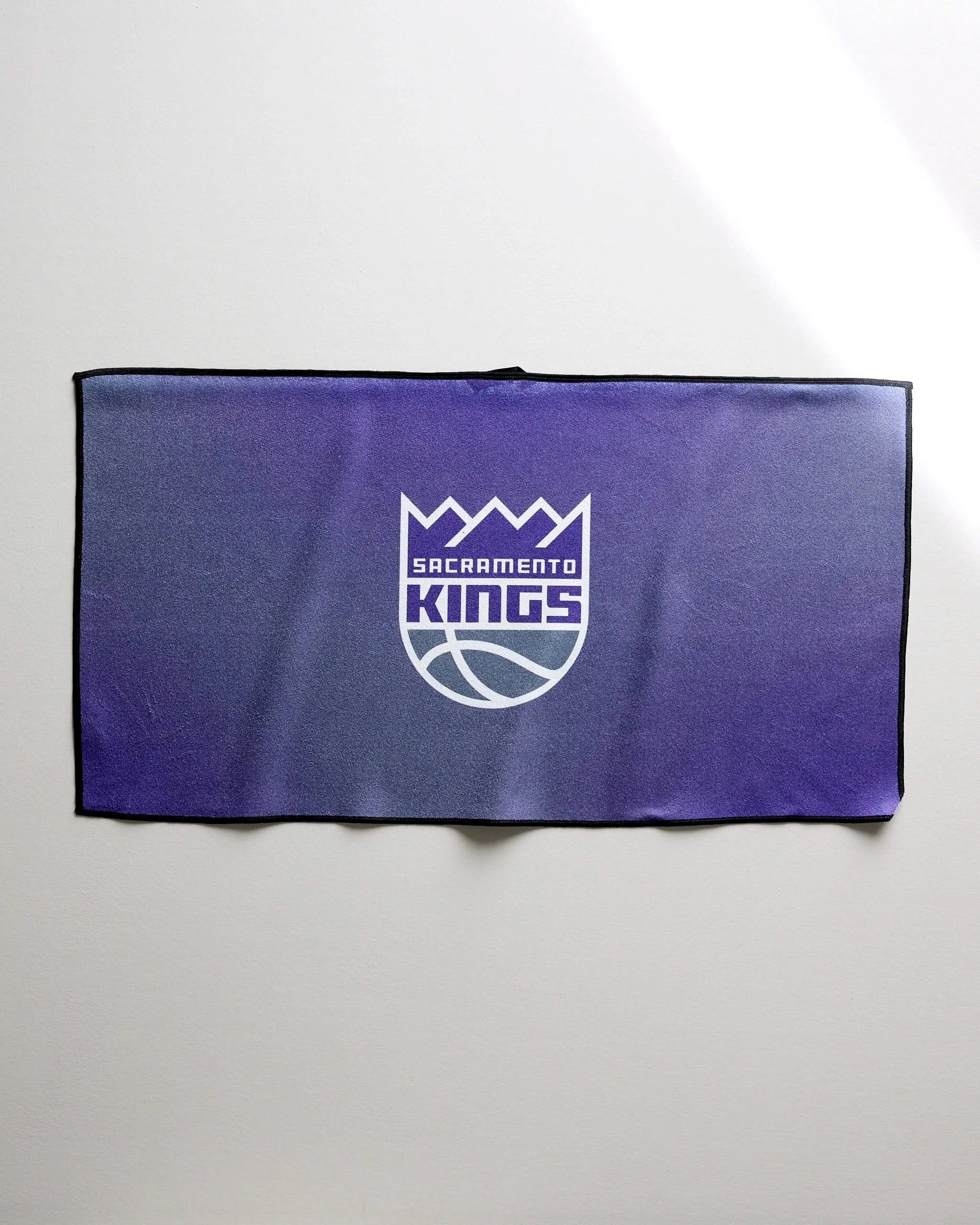 The Kings Fade towel by NBALAB x Geometry, in purple with the Sacramento Kings logo in white and silver, is shown laid flat on a plain light background.