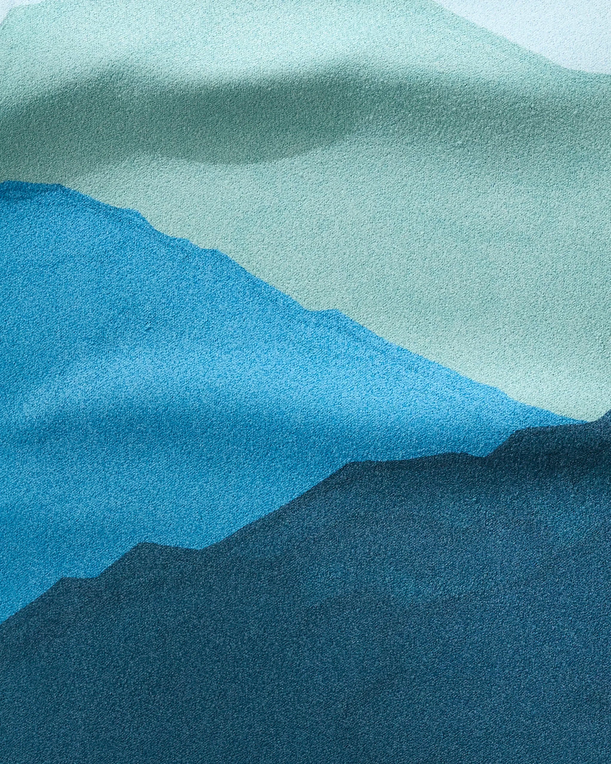 GEOMETRY’s Landscape features abstract, layered mountains in blue and teal with a textured effect recalling recycled materials, creating depth and a calming natural scene.