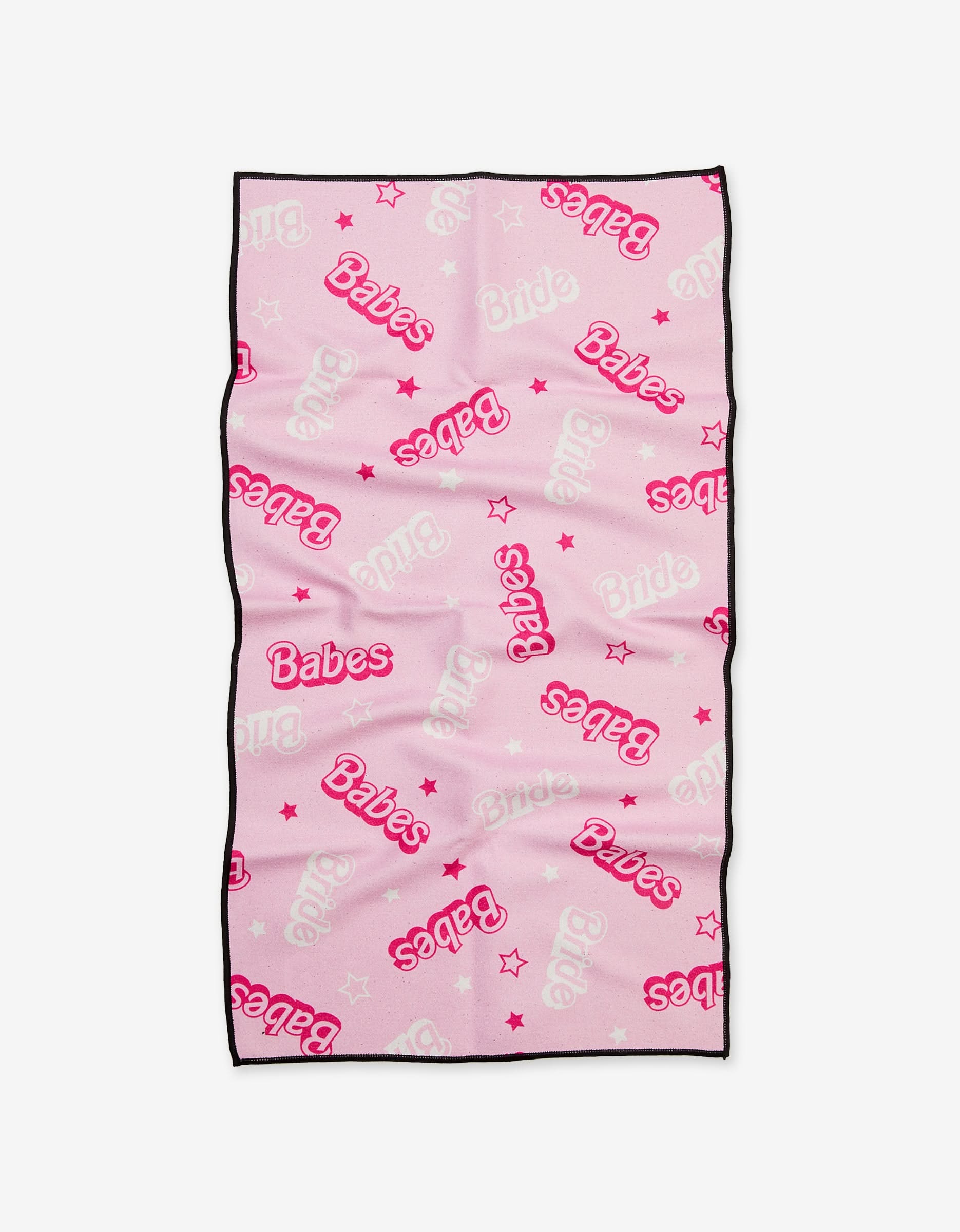 The Lets Go Party Fitness Towel by GEOMETRY is light pink, ultra-absorbent, features Babes and Bride in pink and white with small stars, has black edge trim, and is made using post-consumer recycled materials.