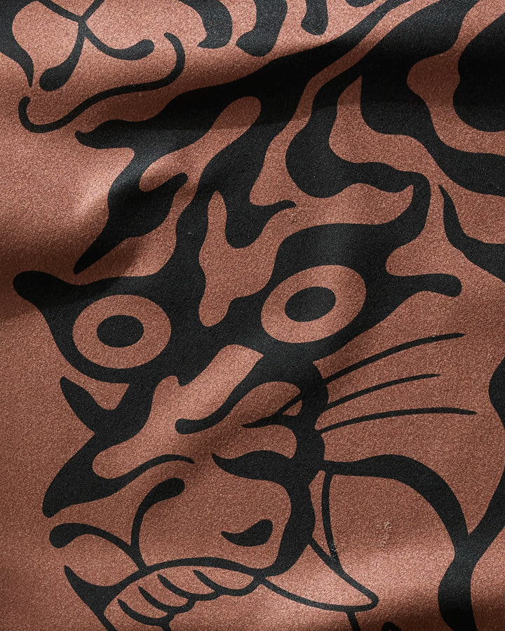 A close-up of Cole Strem’s Panther In Brown: an ultra-absorbent fitness towel featuring a bold black outline of an intense panther face on brown fabric, highlighting its piercing eyes, whiskers, and clenched mouth.