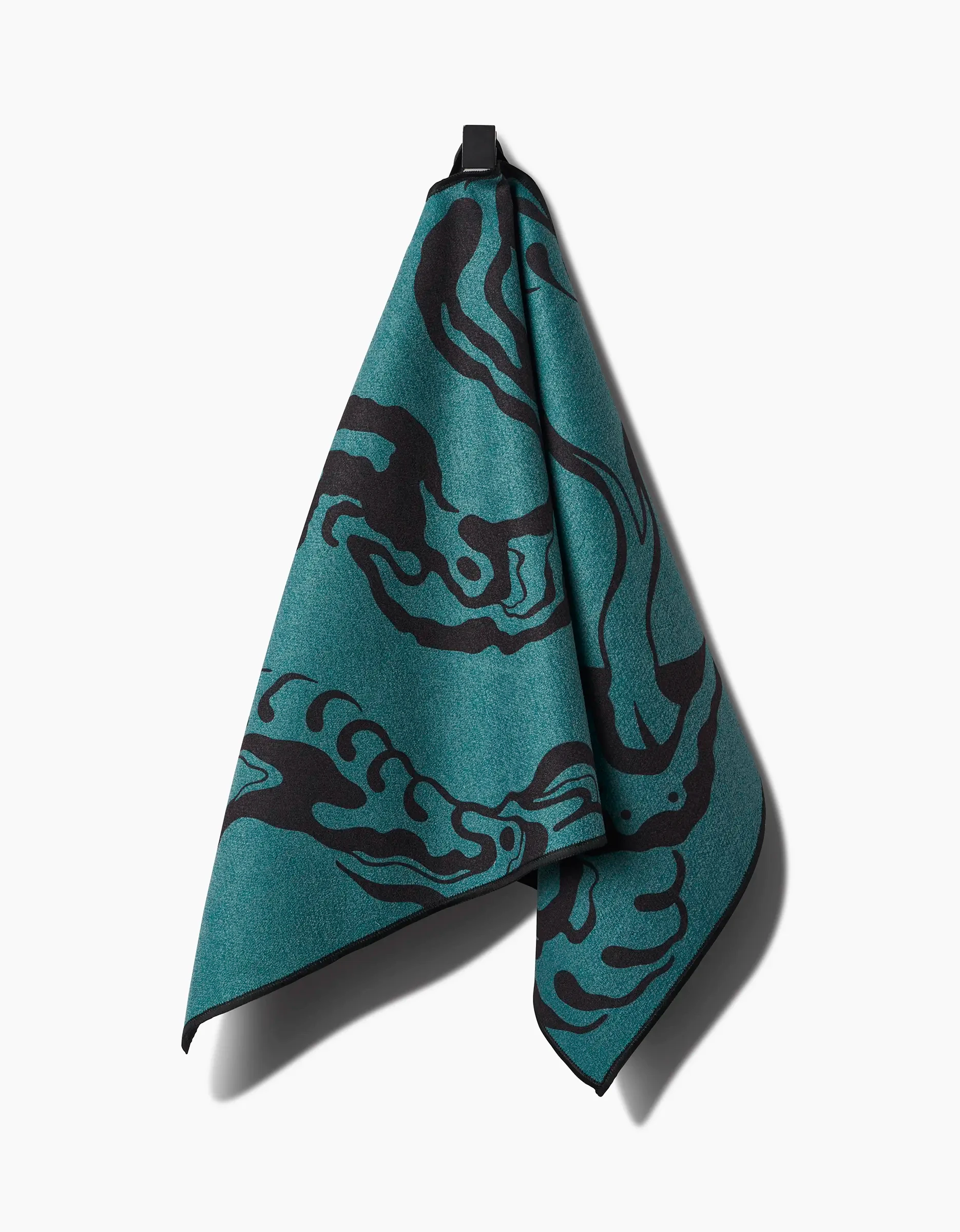 The Cole Strem Snake Fitness Towel, featuring teal color with abstract black patterns and made from ultra-absorbent recycled materials, is shown hanging by its black loop against a white background.
